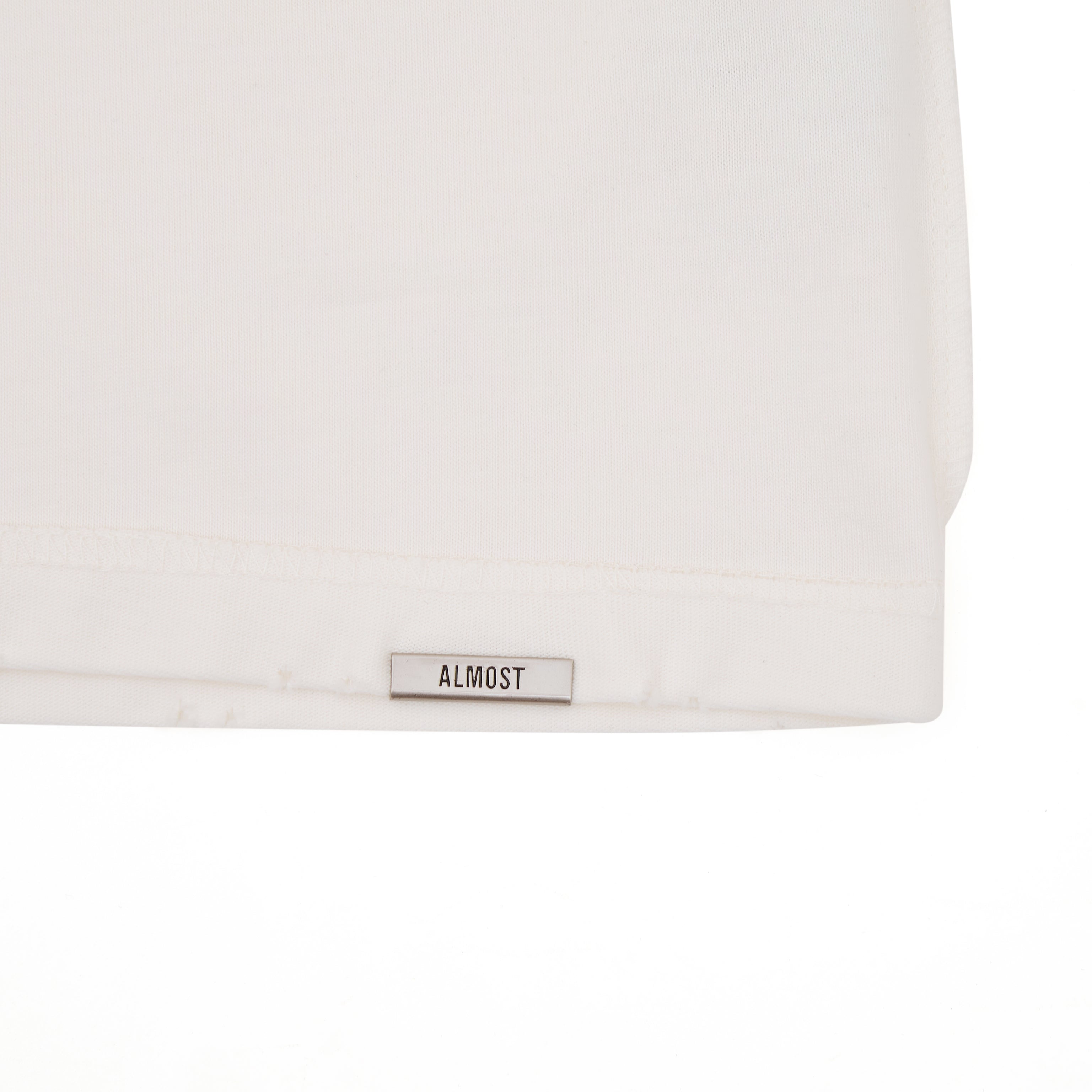 Close-up of a white shirt with a 'ALMOST' label on a white background