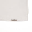 Close-up of a white shirt with a 'ALMOST' label on a white background