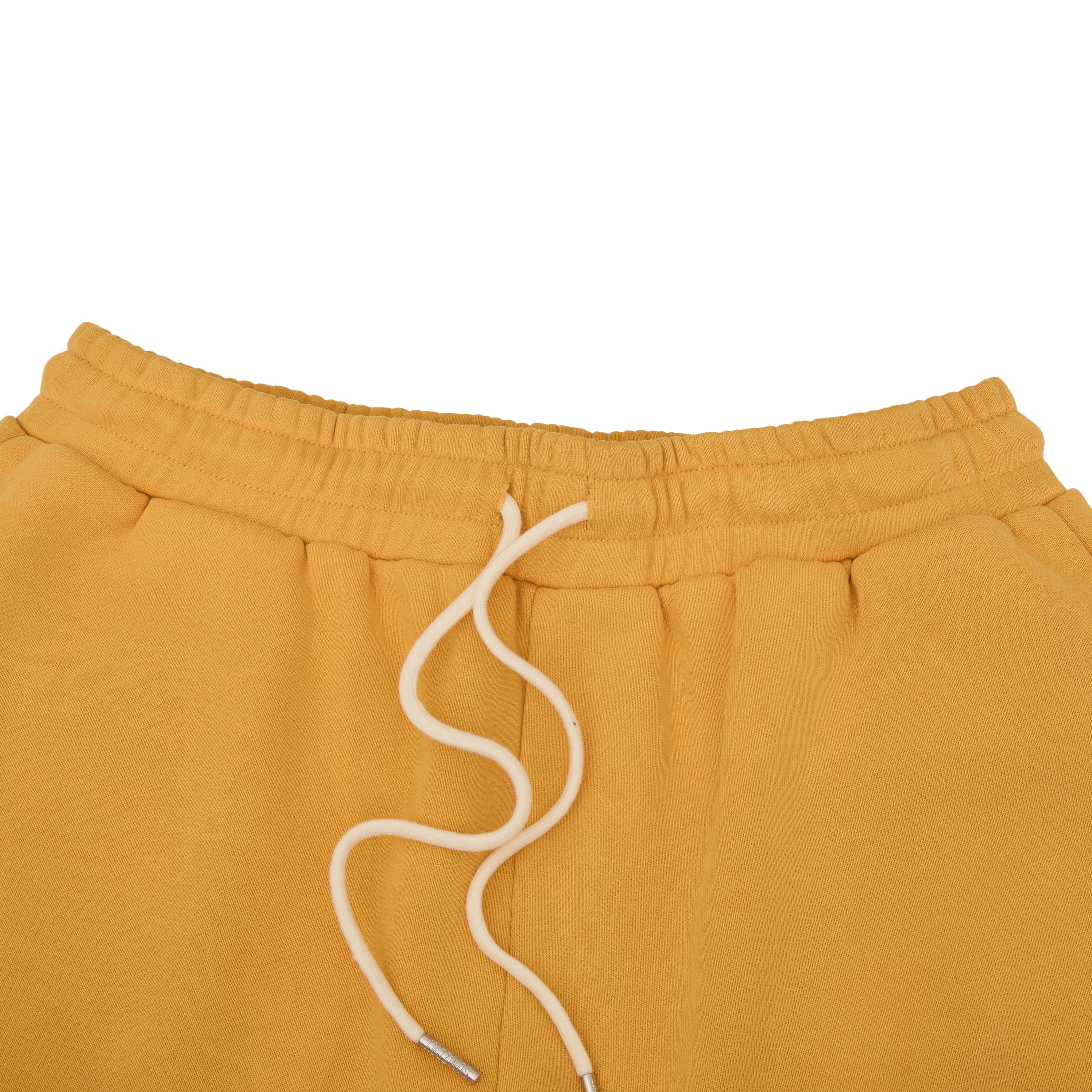 Mustard yellow sweatshorts with a white drawstring on a white background