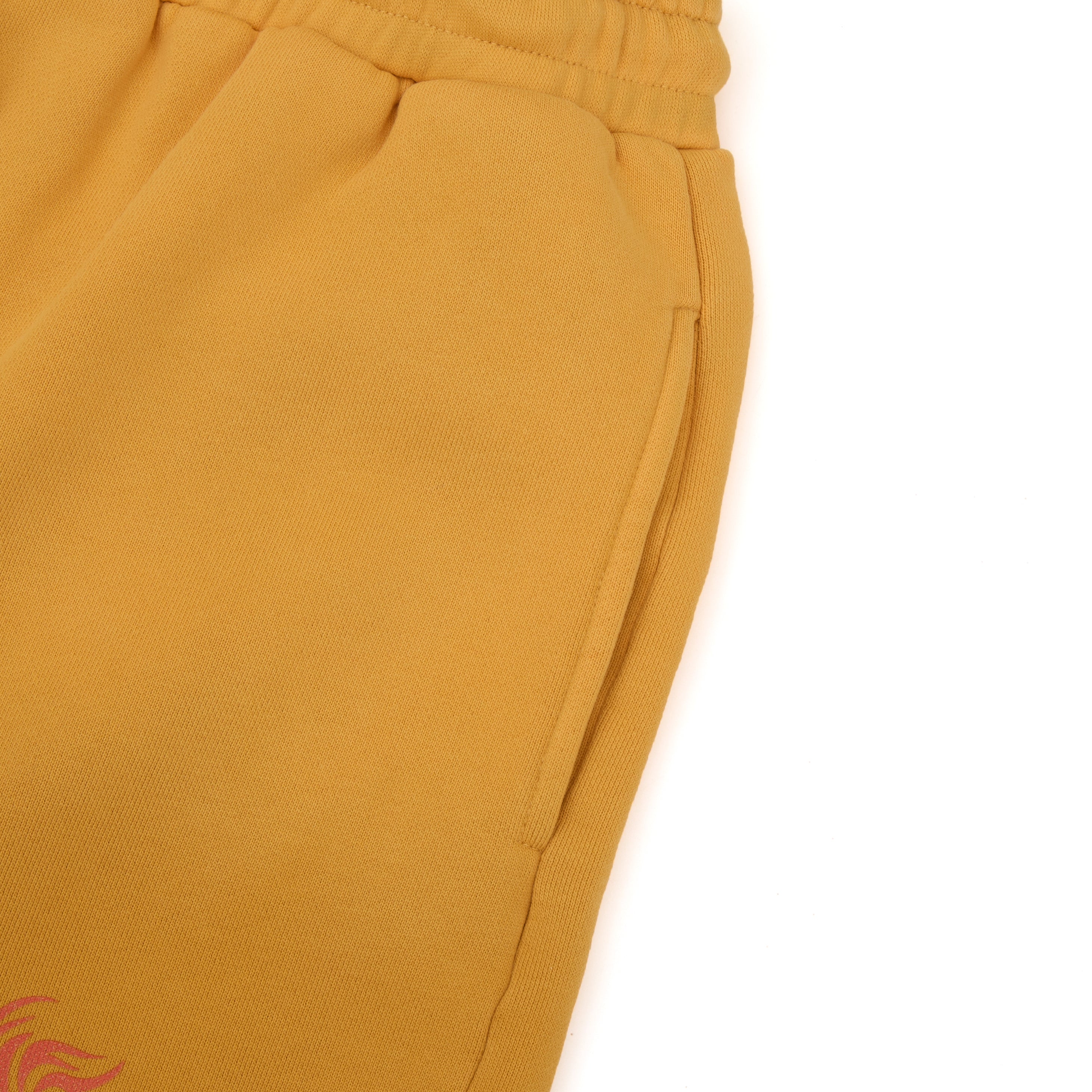 Close-up of mustard yellow sweatshorts on a white background