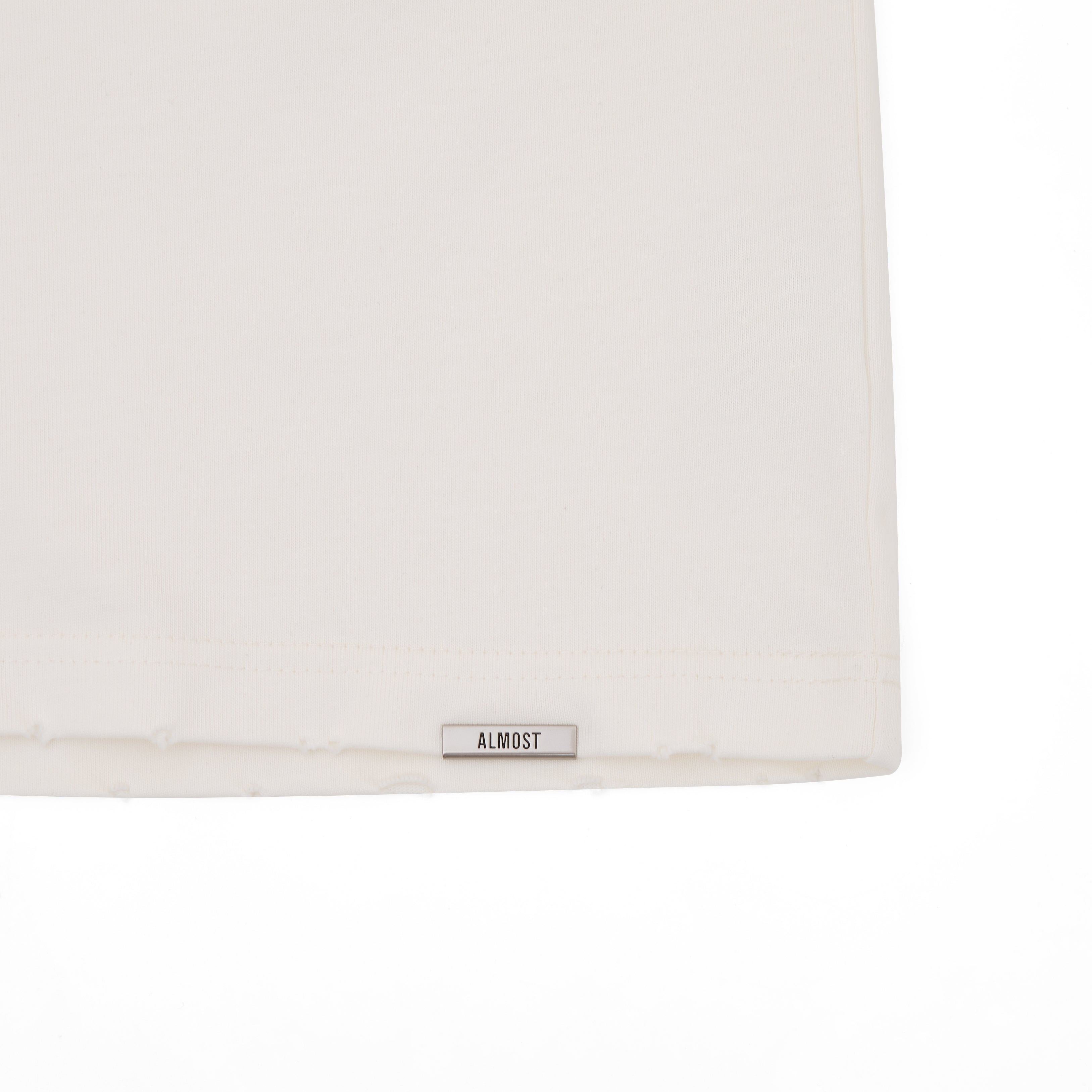 White pillow with 'ALMOST' label on a white background
