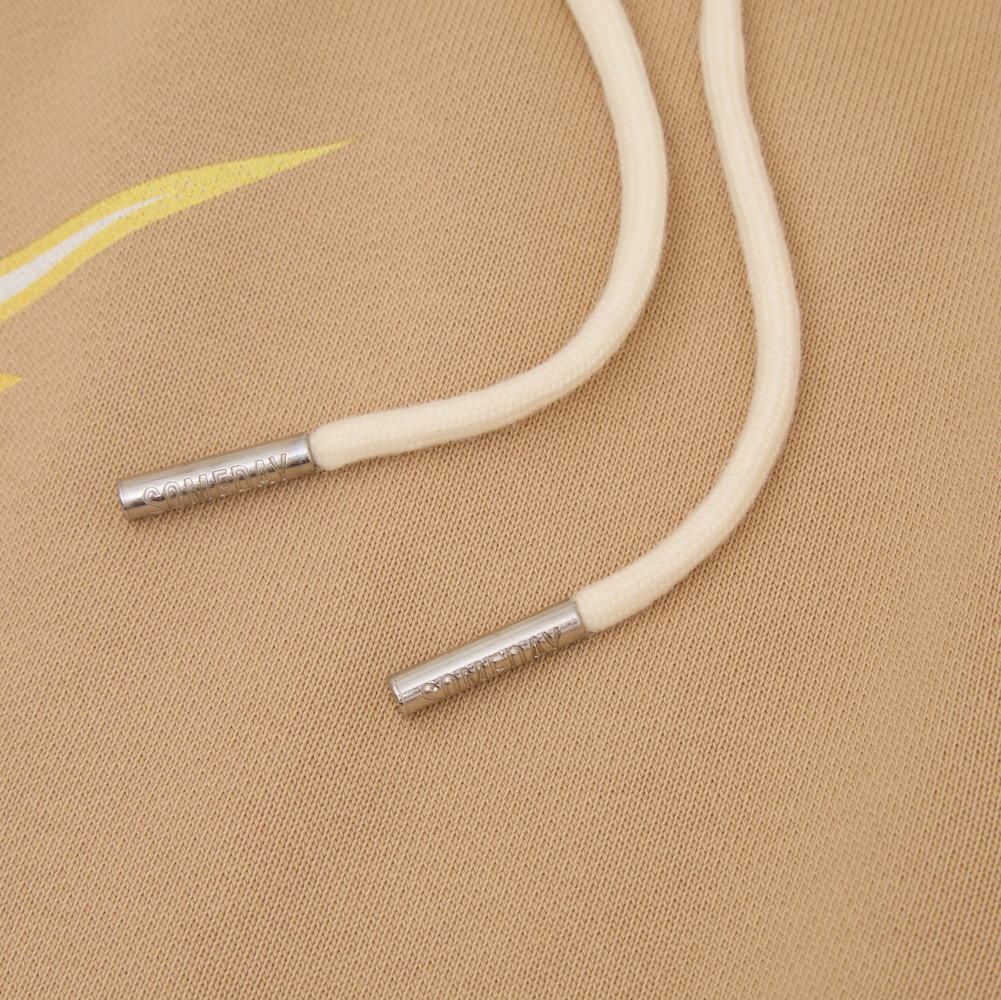 White drawstring with metal eyelets on a beige fabric background