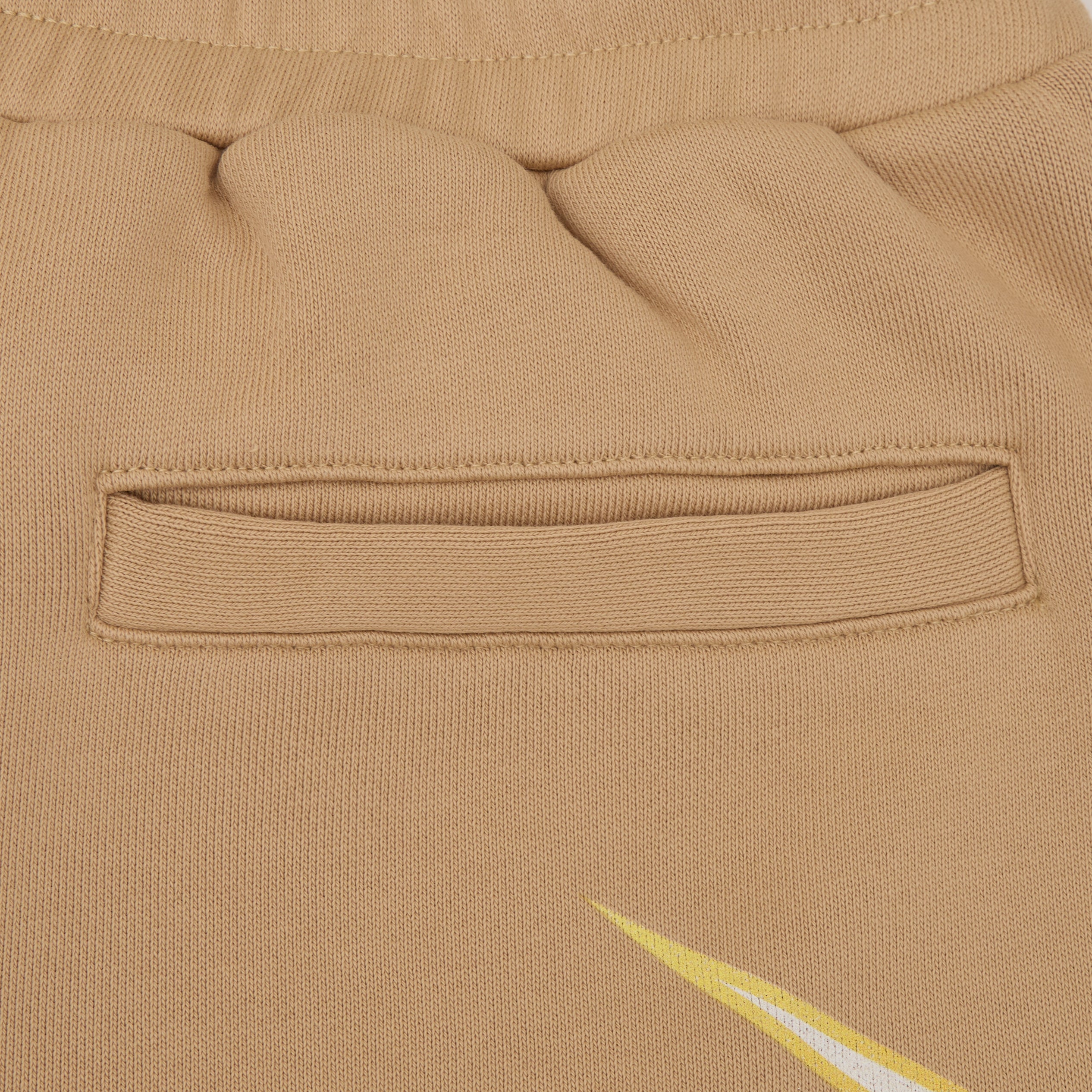 Close-up of a beige fabric pocket with a brand logo.