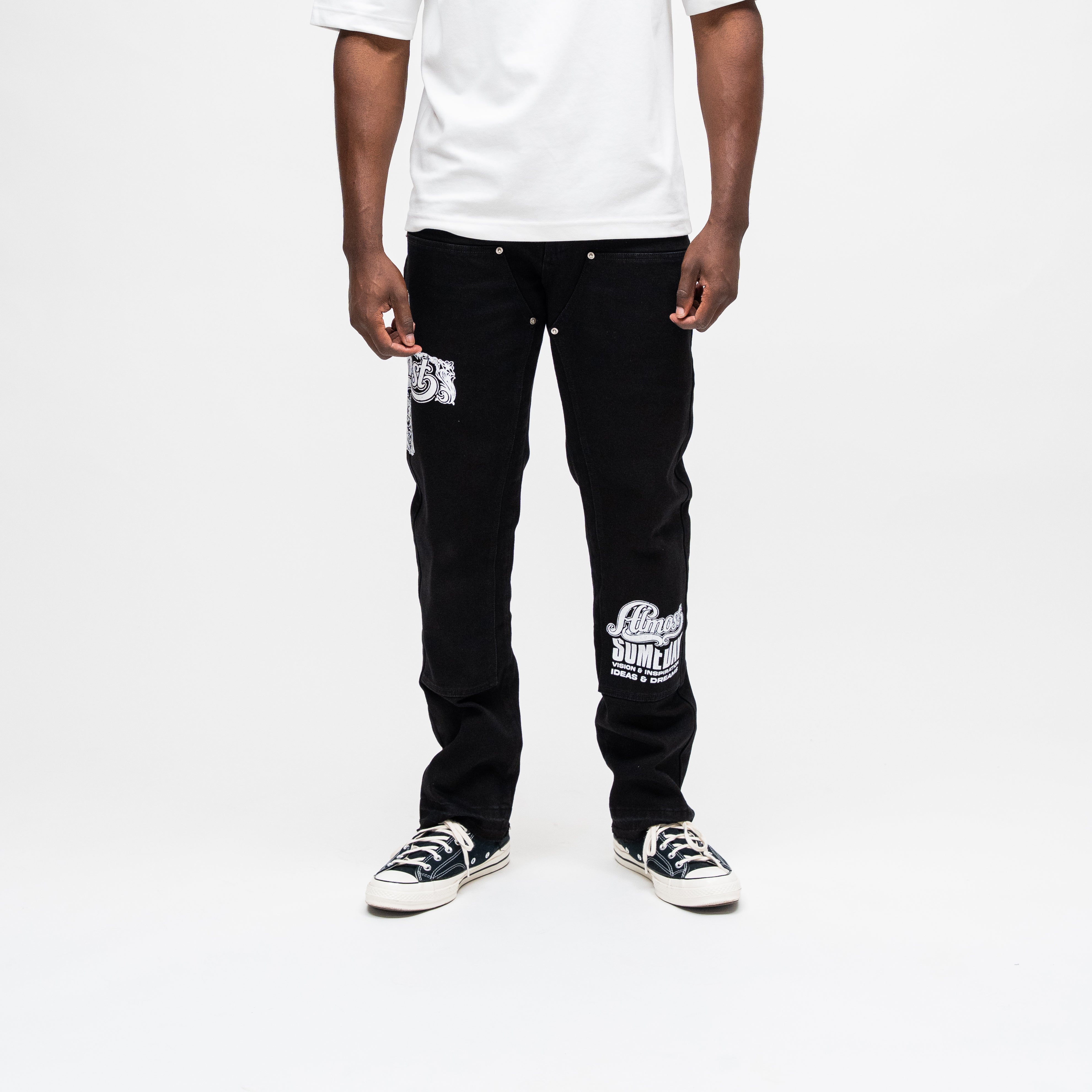 ALMOST SOMEDAY Vision Carpenter Pant in Black, front view with ornate thigh graphic and script leg print
