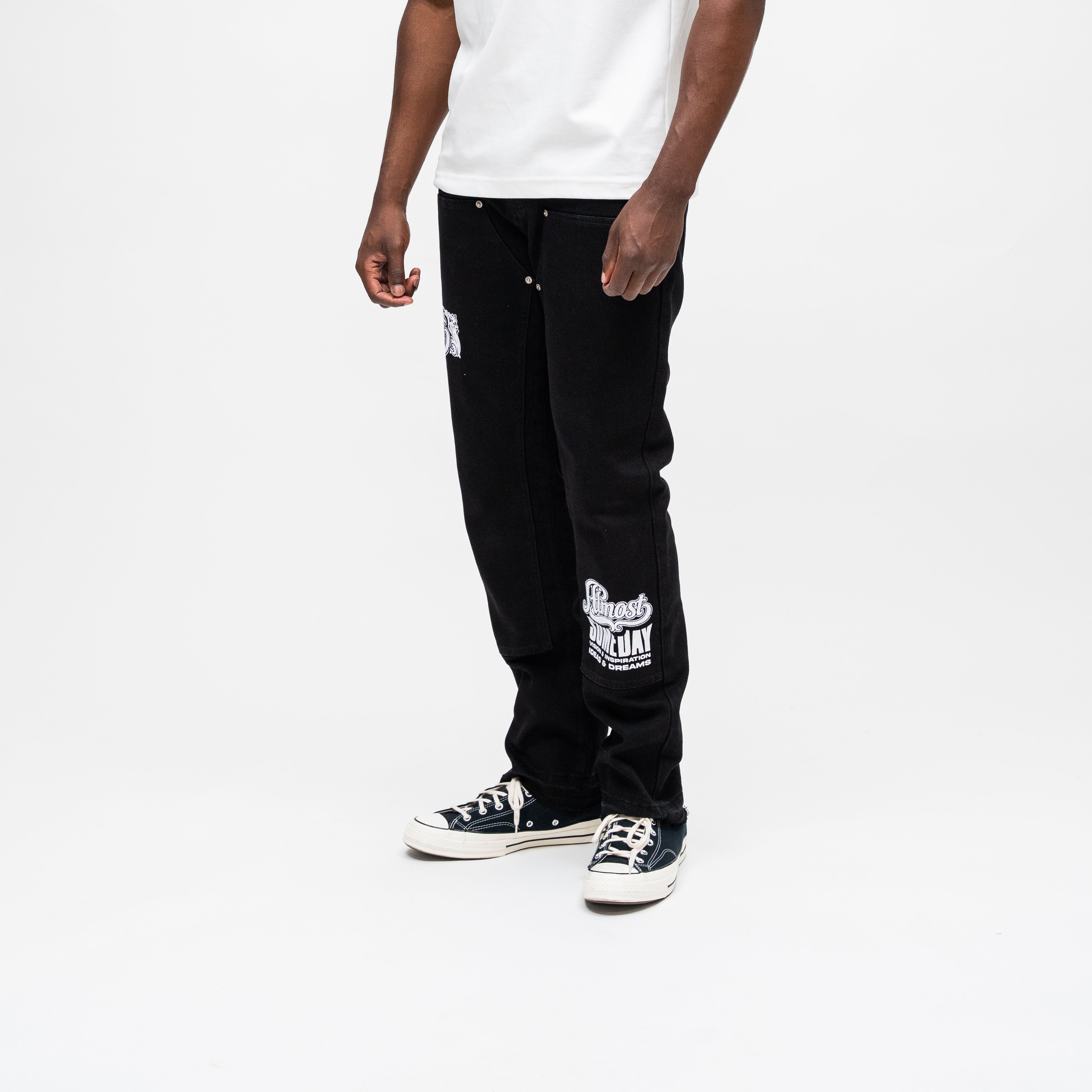 ALMOST SOMEDAY Vision Carpenter Pant in Black, angled side view showing script graphic on right lower leg