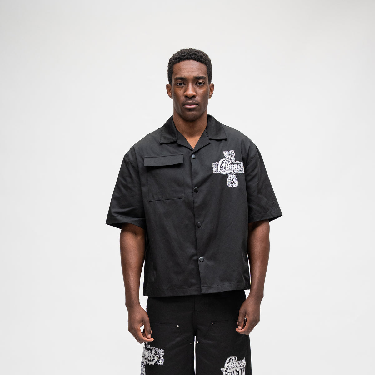 ALMOST SOMEDAY Vision Nylon Shirt in Black, front view with ornate cross graphic on right chest and utility pocket