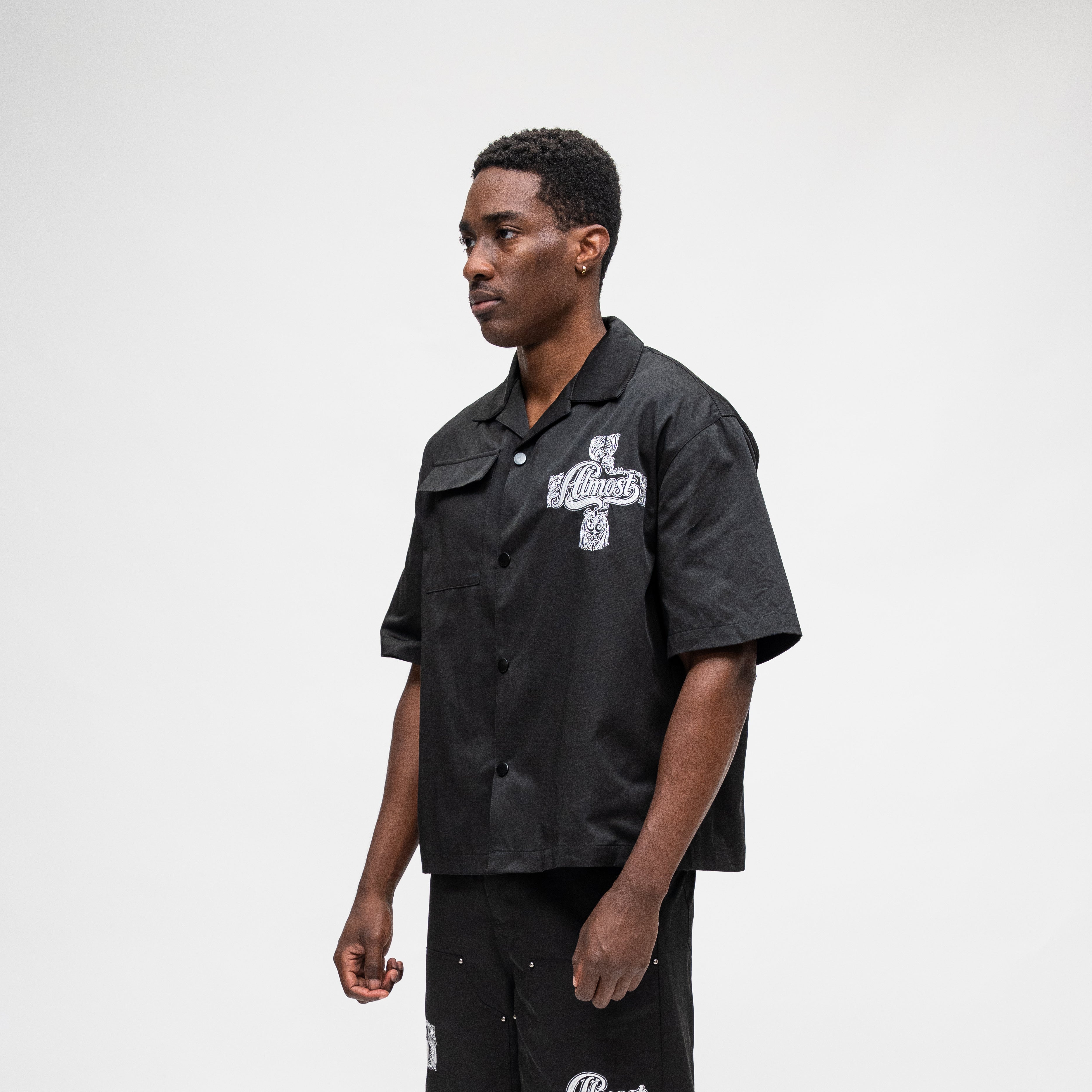 ALMOST SOMEDAY Vision Nylon Shirt in Black, lifestyle shot angled front view showing camp collar and boxy fit
