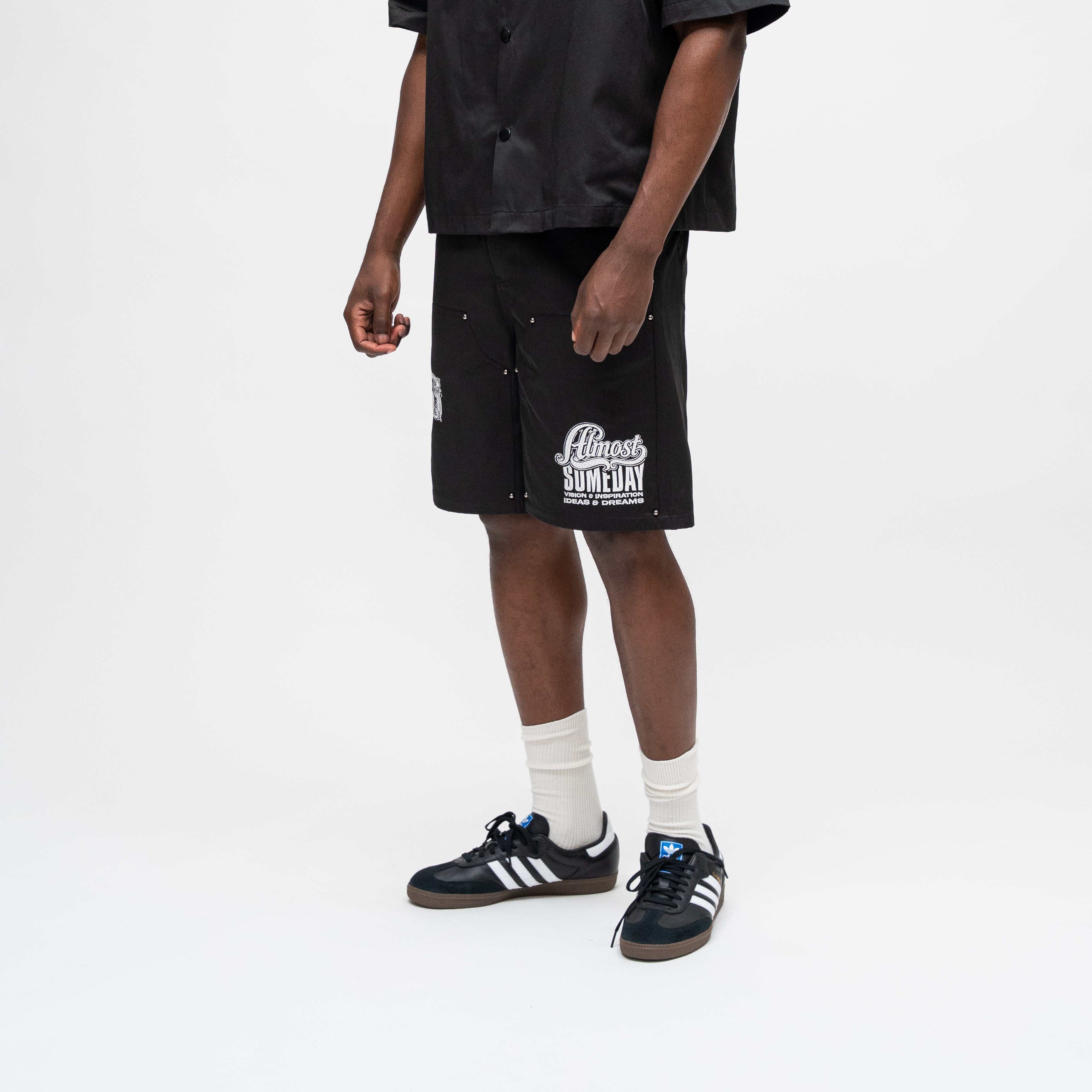 ALMOST SOMEDAY Vision Nylon Short in Black, lifestyle shot angled front view showing script graphic and snap side seam detail