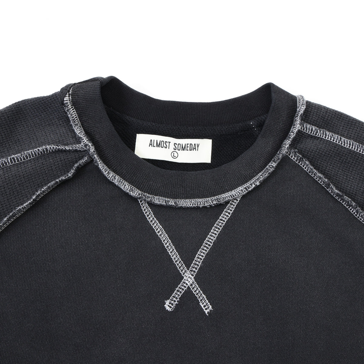 Alumni Crewneck – Black – Close-up of ribbed crew neckline, crossed white stitching, and Almost Someday size label