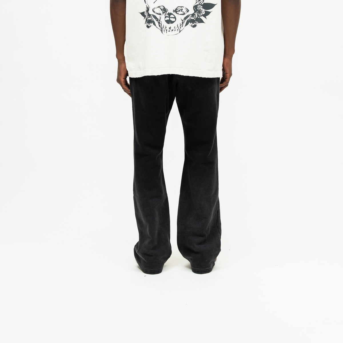 Enemies Flare Bottoms – Black – Back view on model styled with a cream tee, showing plain back and flared legs