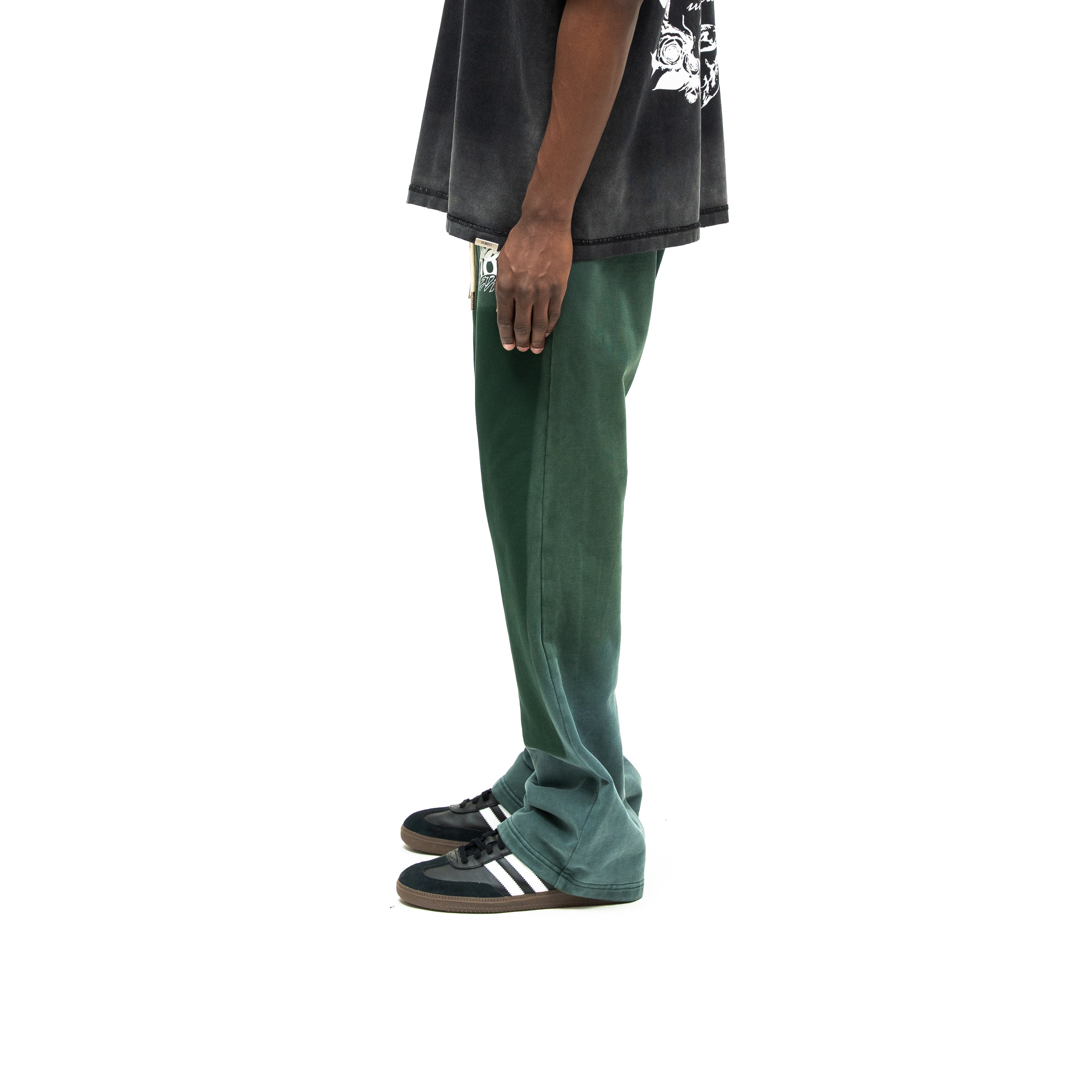 Enemies Flare Bottoms – Green – Side view on model styled with a black tee, showing side seam and flared hem