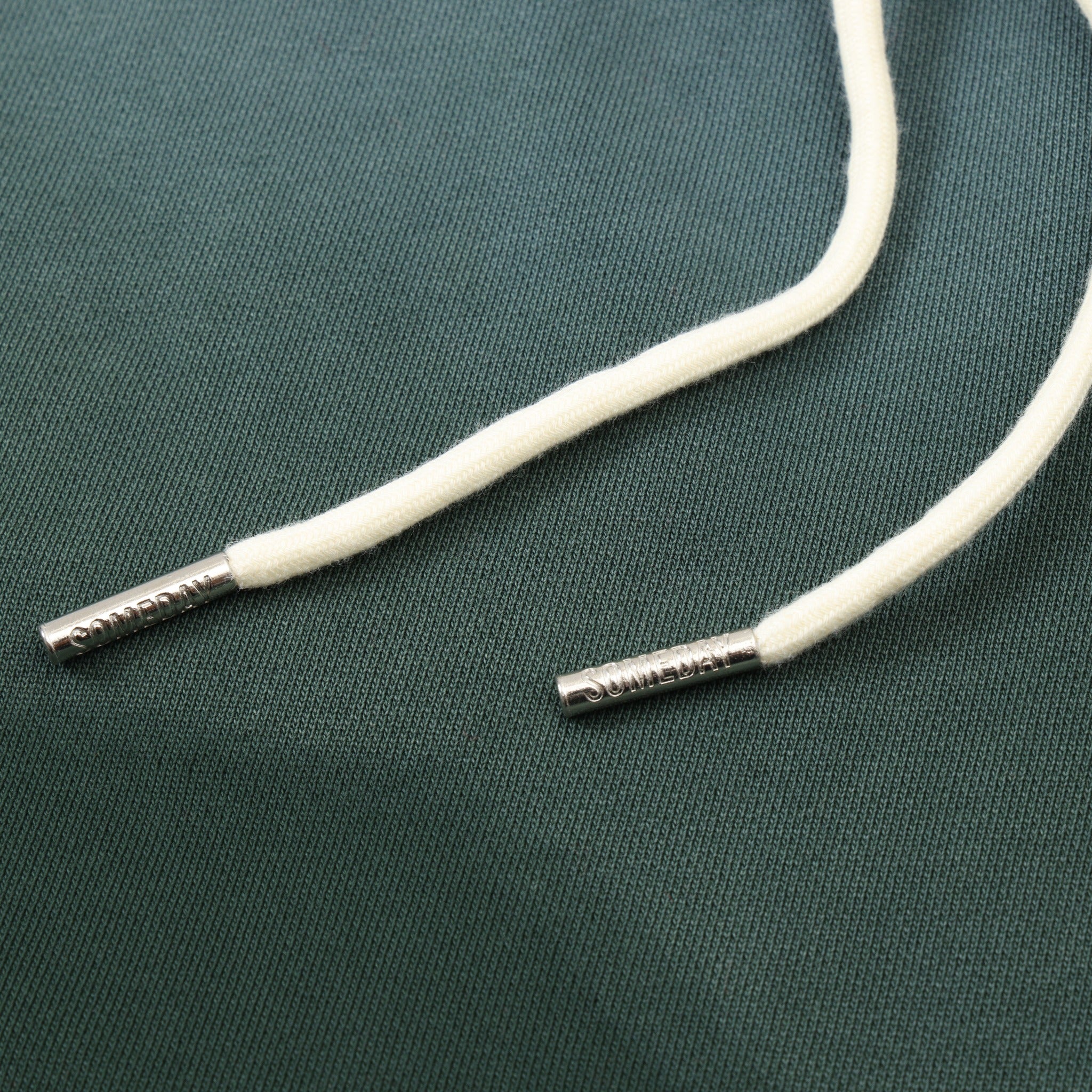 Enemies Flare Bottoms – Green – Close-up of white drawstrings with silver-tone branded metal tips
