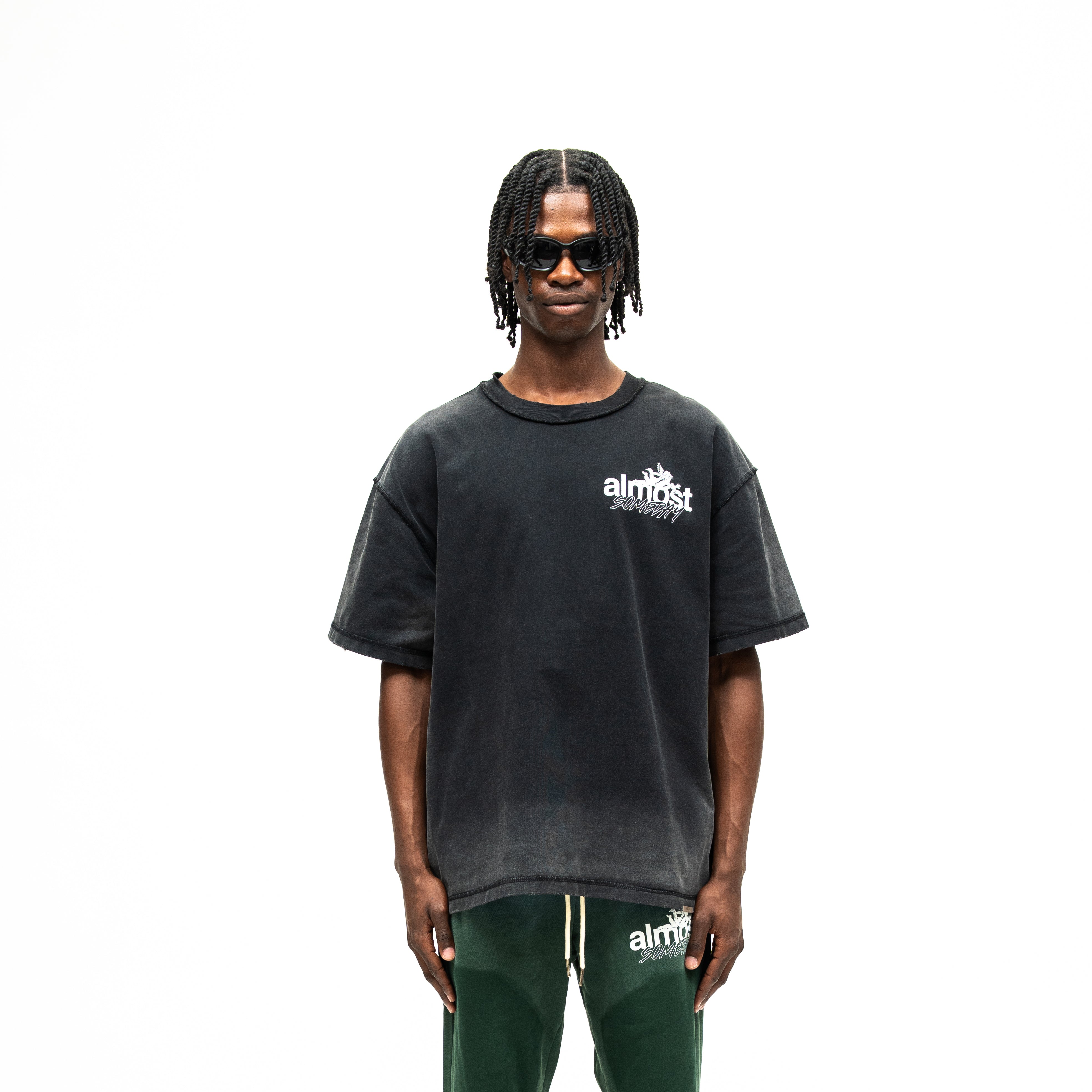 Enemies Tee – Black – Front view on model showing white chest logo, short sleeves, and boxy fit