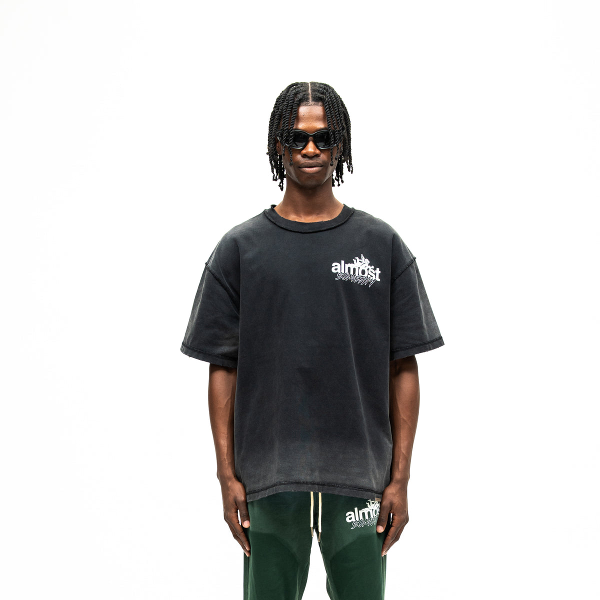 Enemies Tee – Black – Front view on model showing white chest logo, short sleeves, and boxy fit