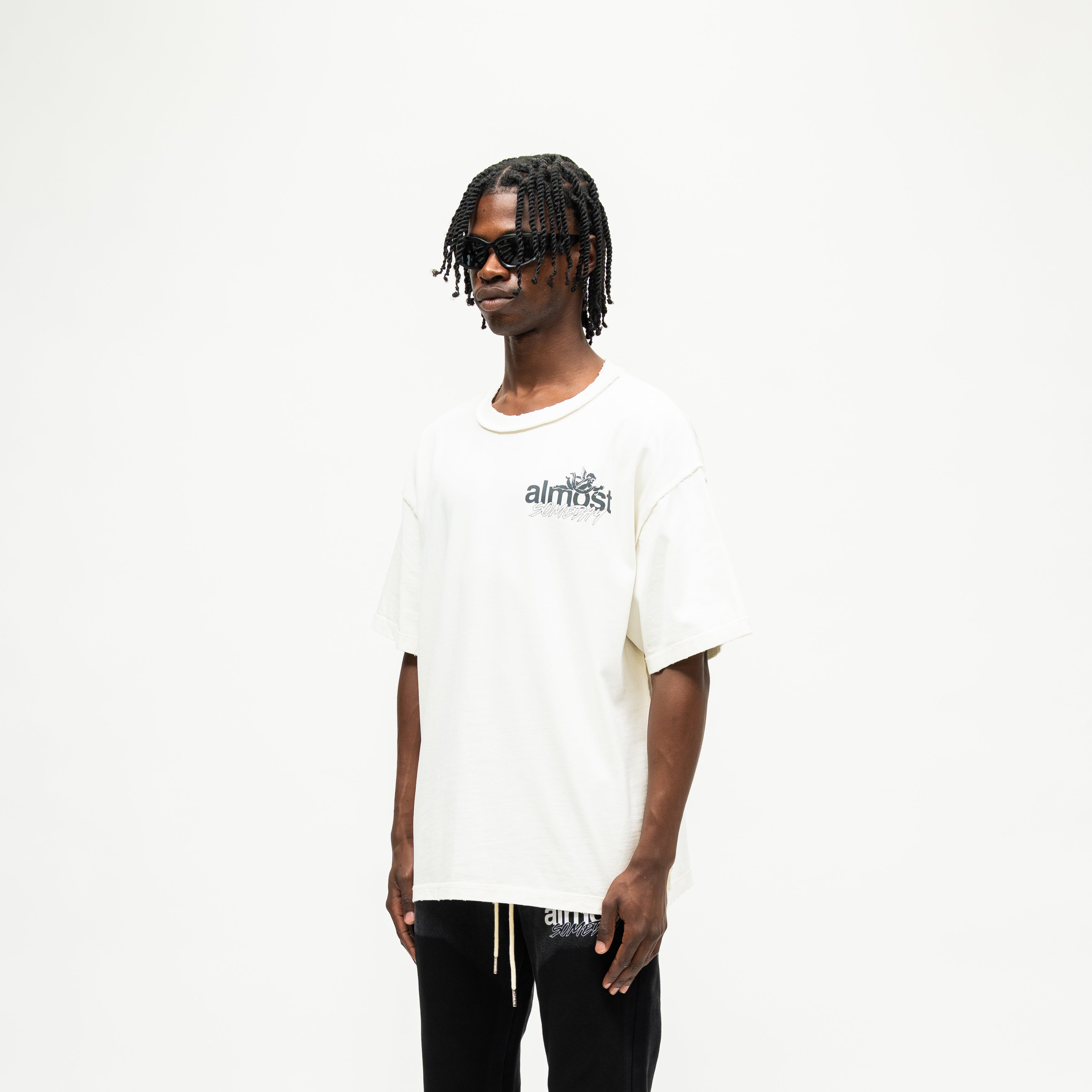Enemies Tee – Cream – Three-quarter front view on model showing chest logo and dropped shoulders