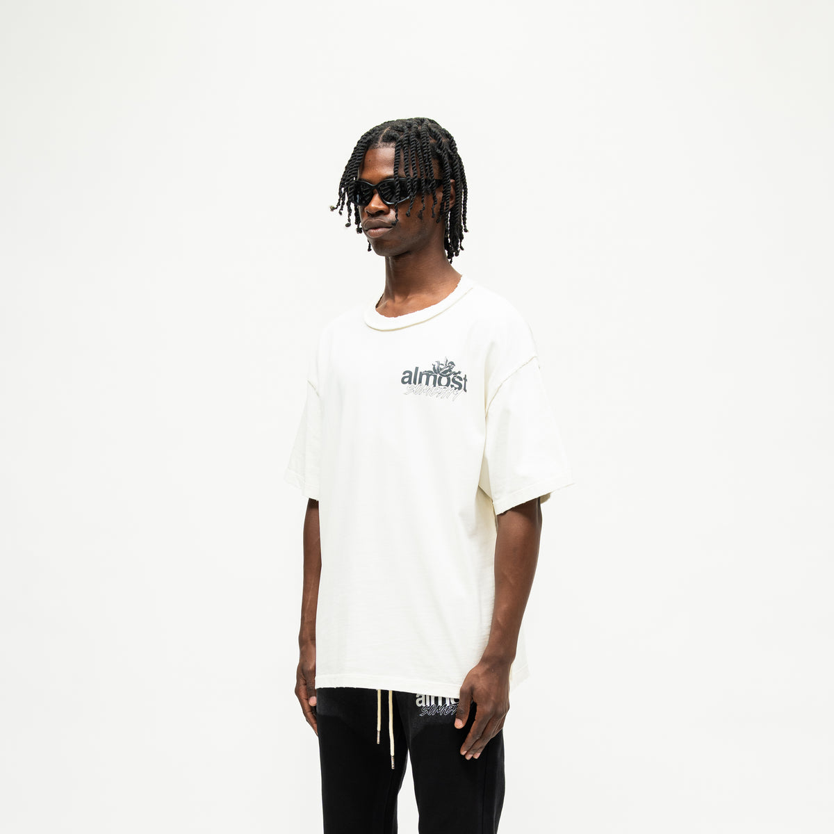 Enemies Tee – Cream – Three-quarter front view on model showing chest logo and dropped shoulders