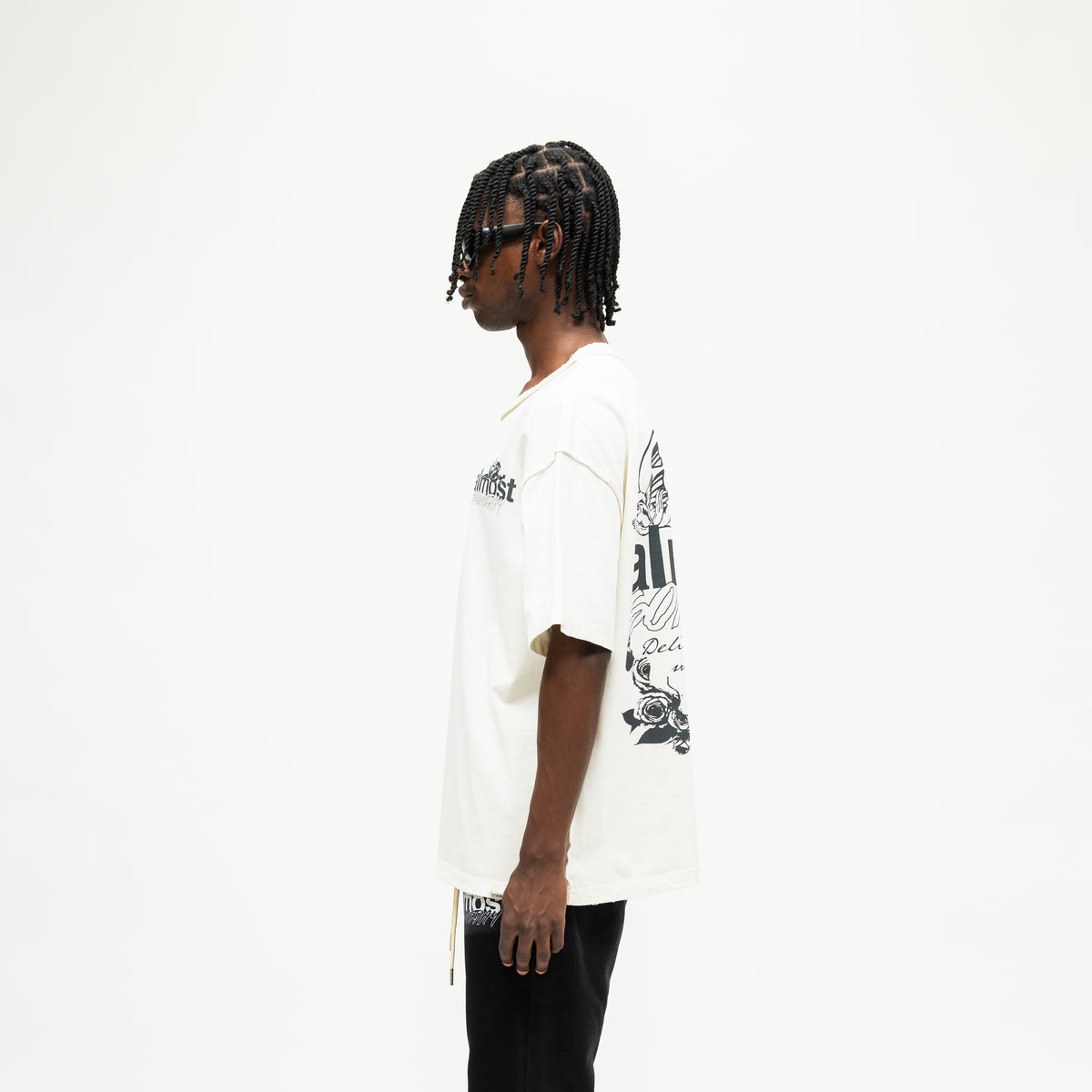 Enemies Tee – Cream – Side view on model showing short sleeves, relaxed silhouette, and partial back graphic