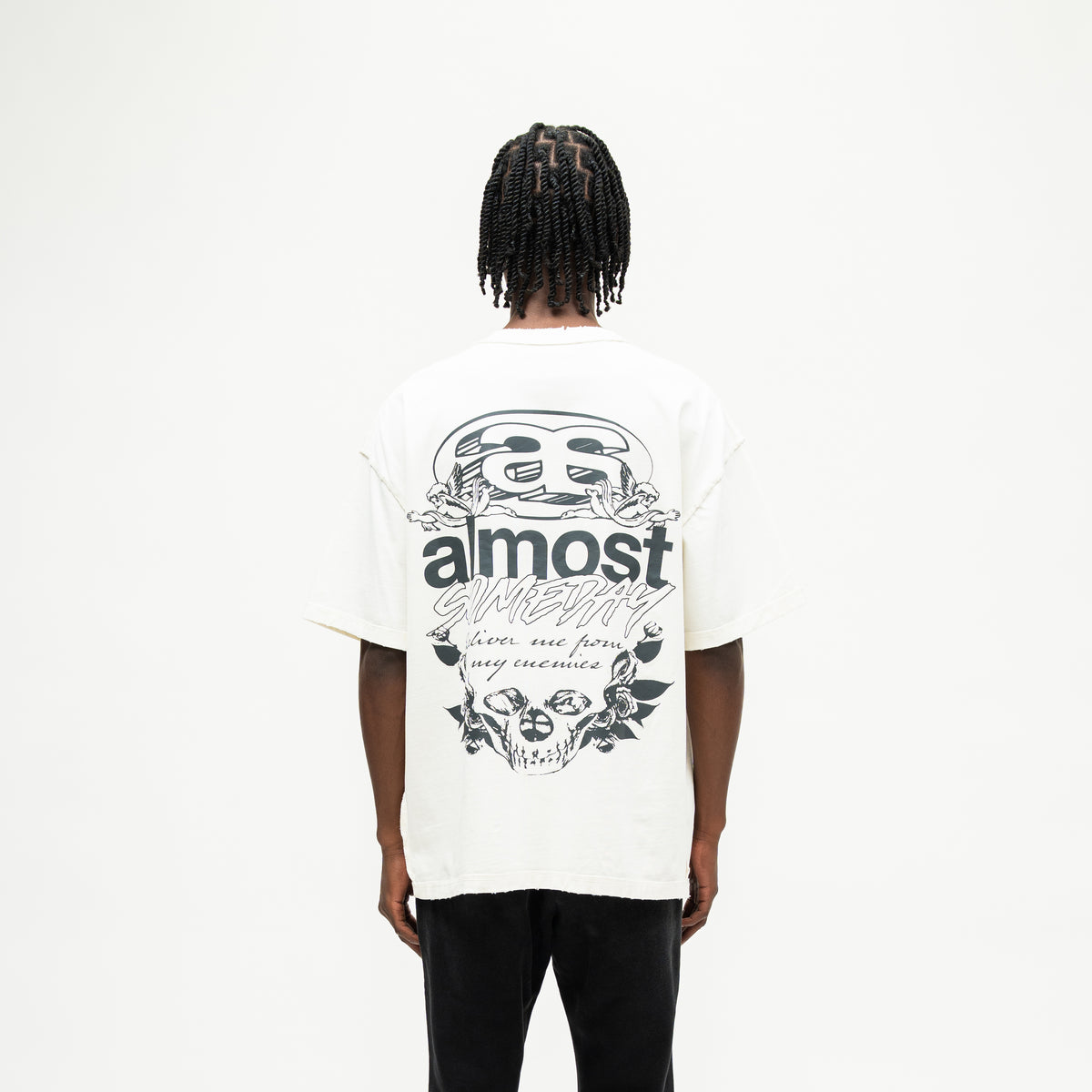 Enemies Tee – Cream – Back view on model showing large black lettering, cherubs, roses, and skull graphic