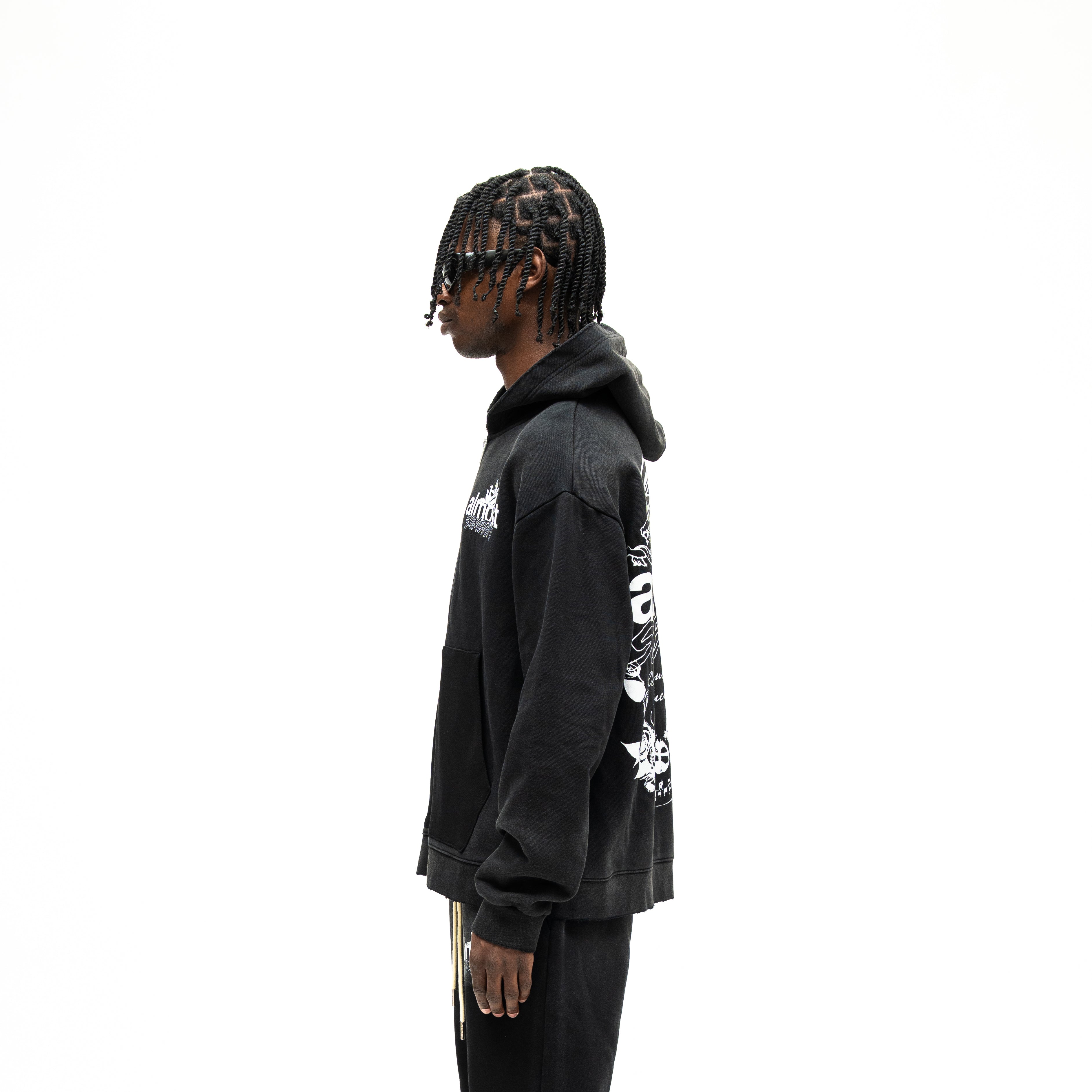 Enemies Zip Hoodie – Black – Side view on model showing hood, long sleeves, and partial back graphic