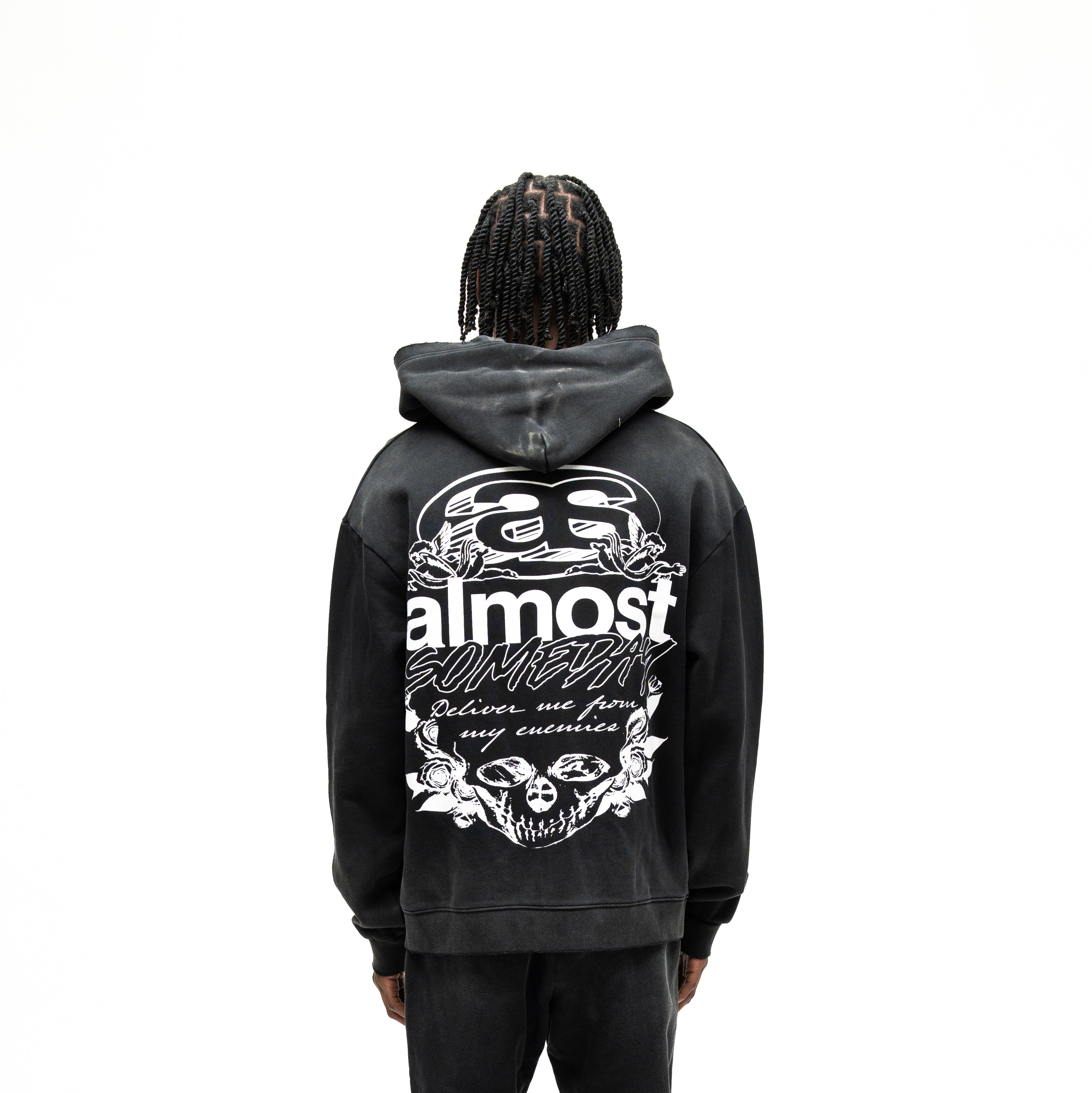 Enemies Zip Hoodie – Black – Back view on model showing large white lettering, cherubs, roses, and skull artwork