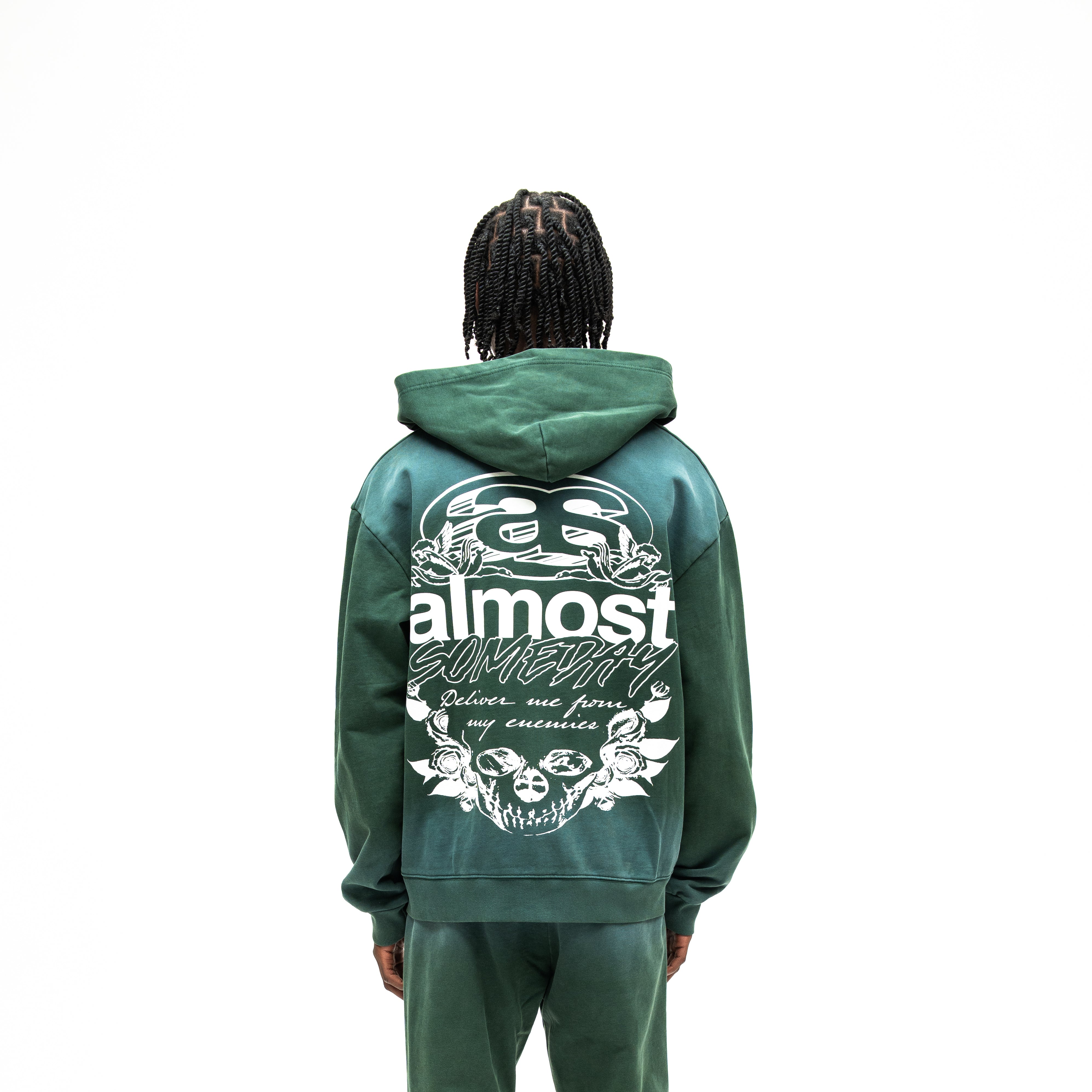 Enemies Zip Hoodie – Green – Back view on model showing large white lettering, cherubs, roses, and skull artwork
