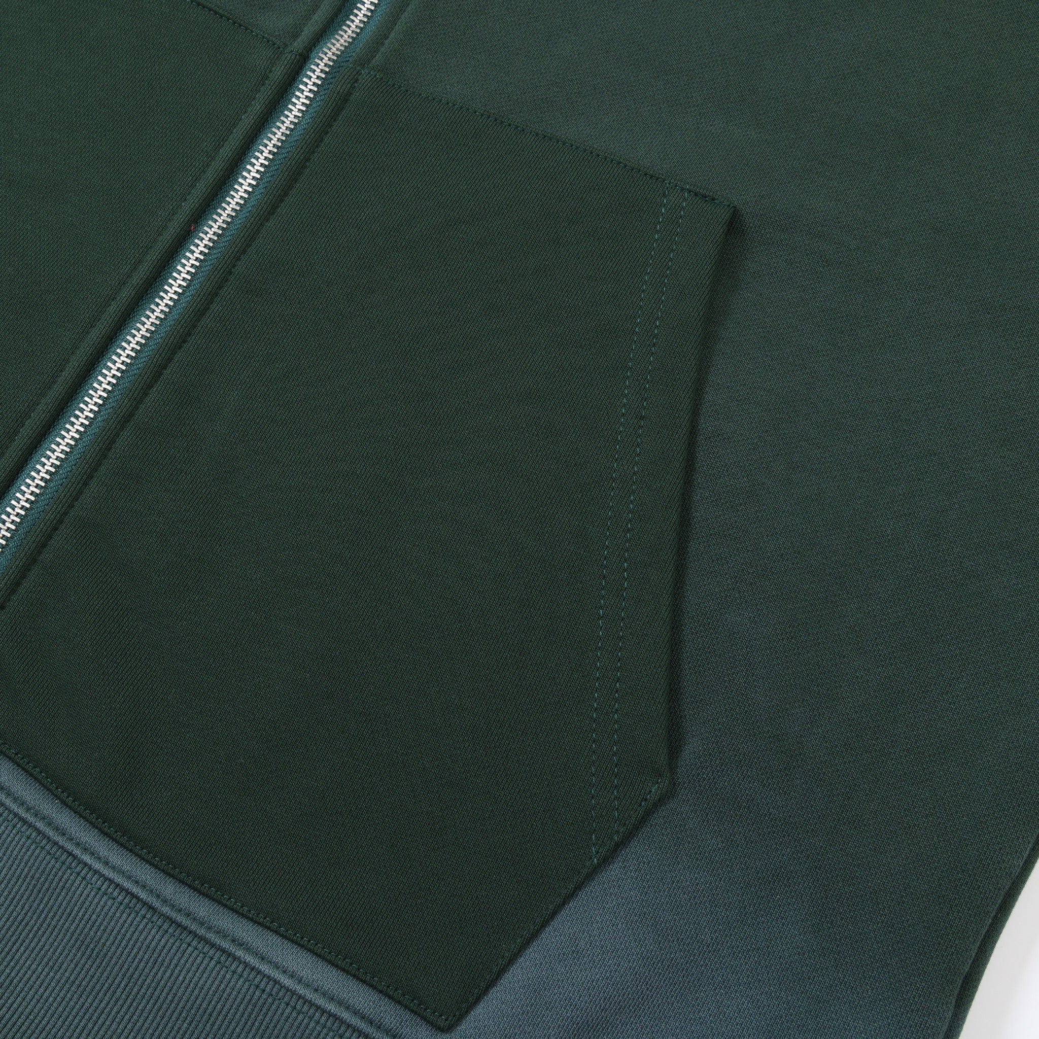 Enemies Zip Hoodie – Green – Close-up of dark green front pocket opening, stitching, and silver-tone zipper teeth