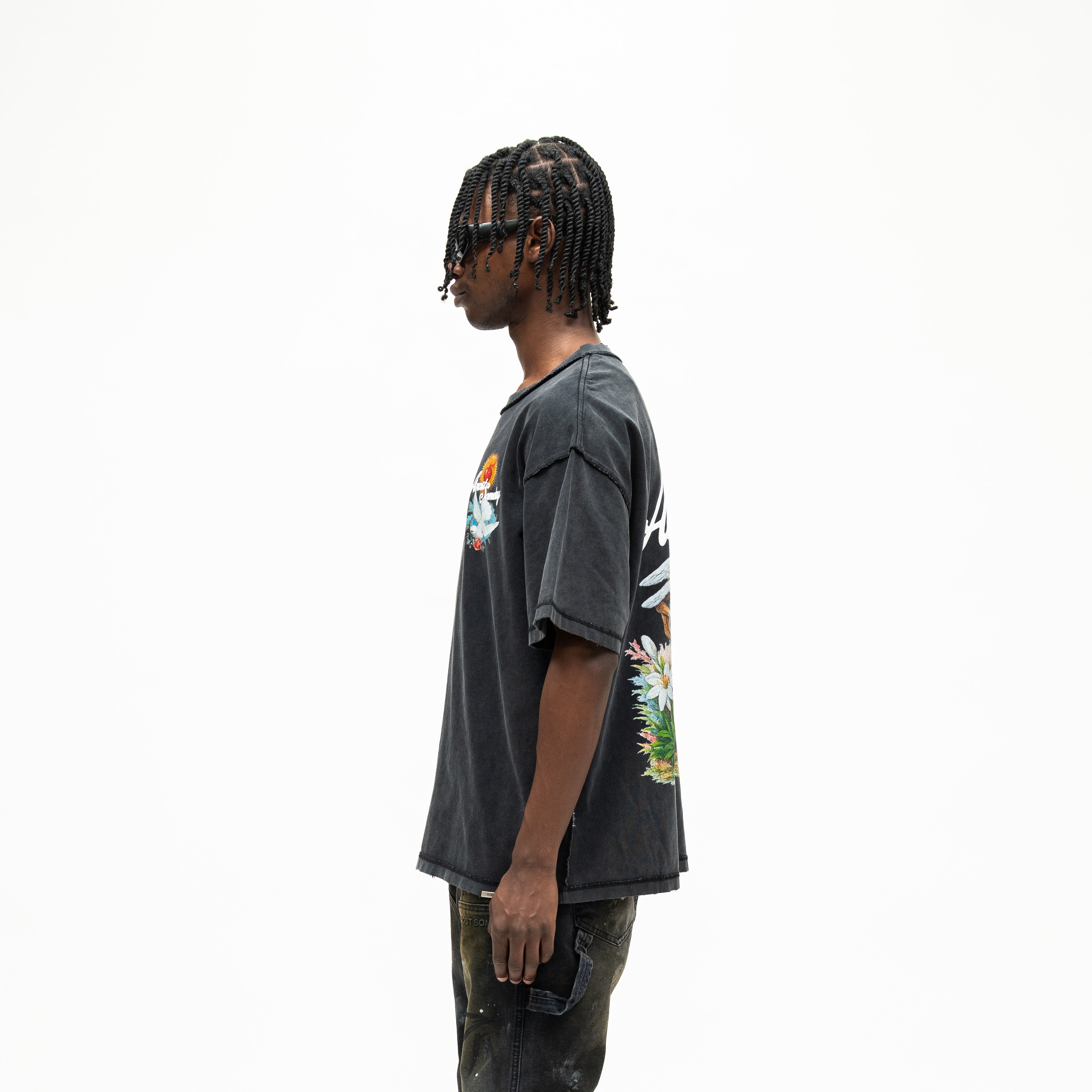Fountain Tee – Black – Side view on model showing short sleeves, relaxed silhouette, and partial fountain back graphic