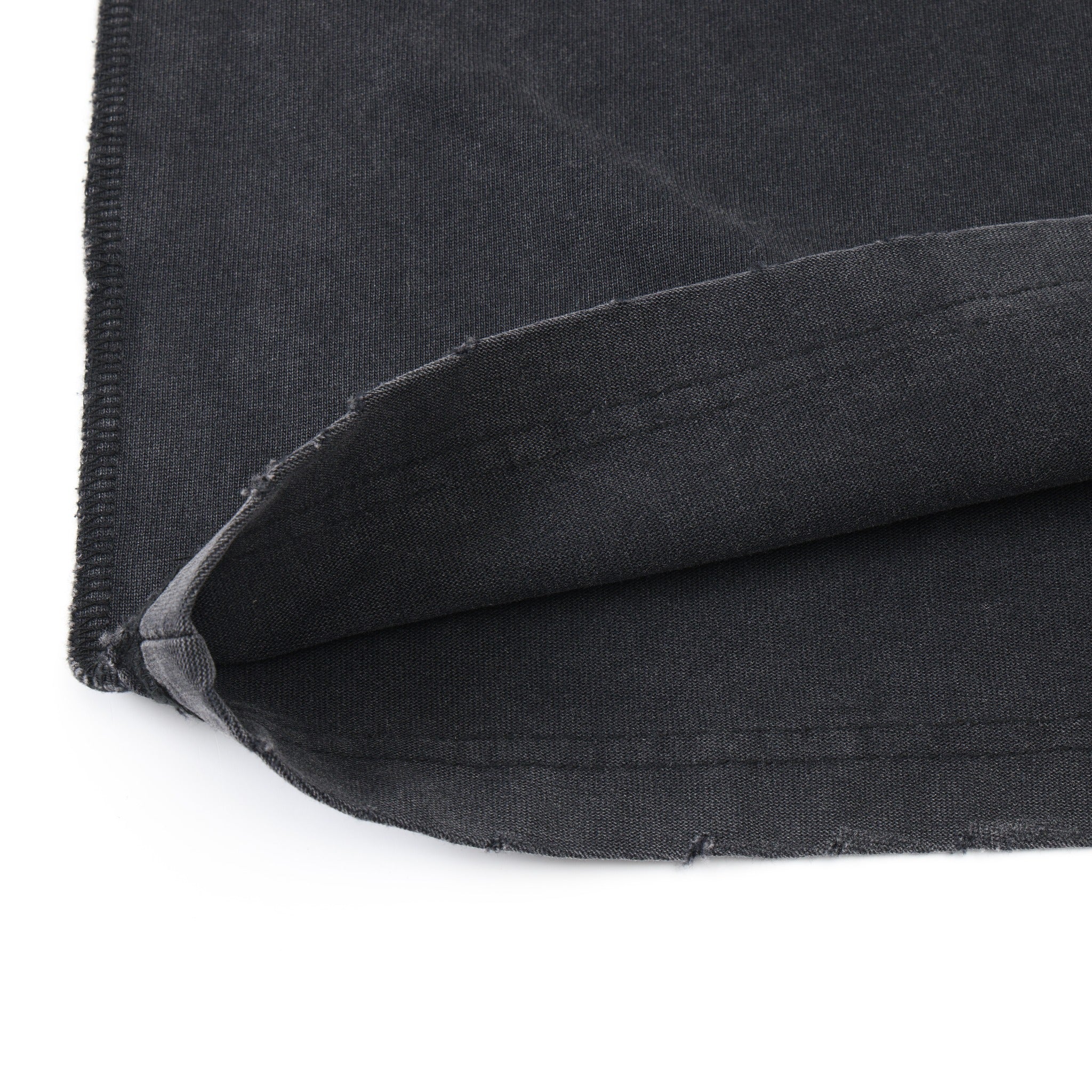 Fountain Tee – Black – Close-up of turned-up distressed hem and fabric underside