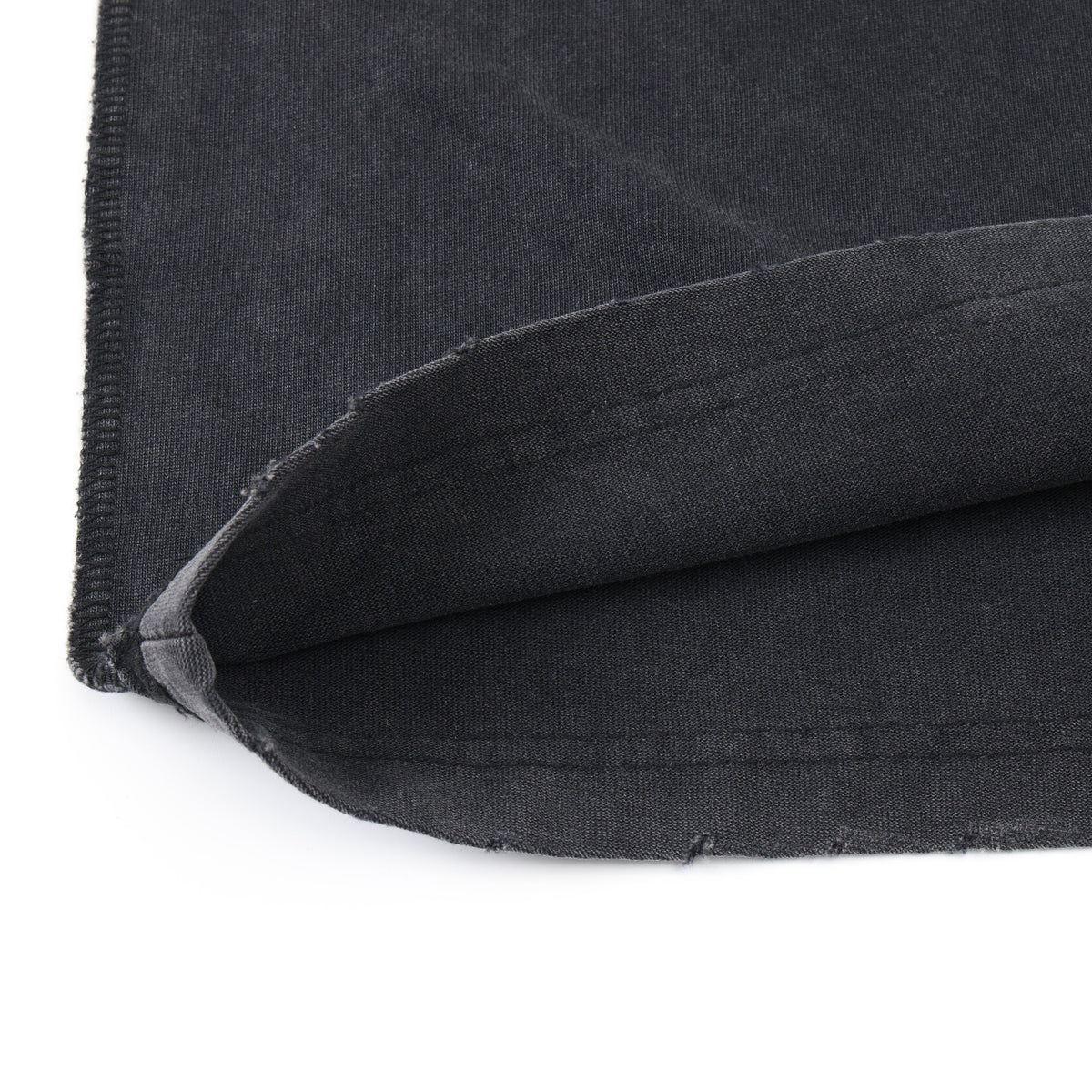 Fountain Tee – Black – Close-up of turned-up distressed hem and fabric underside