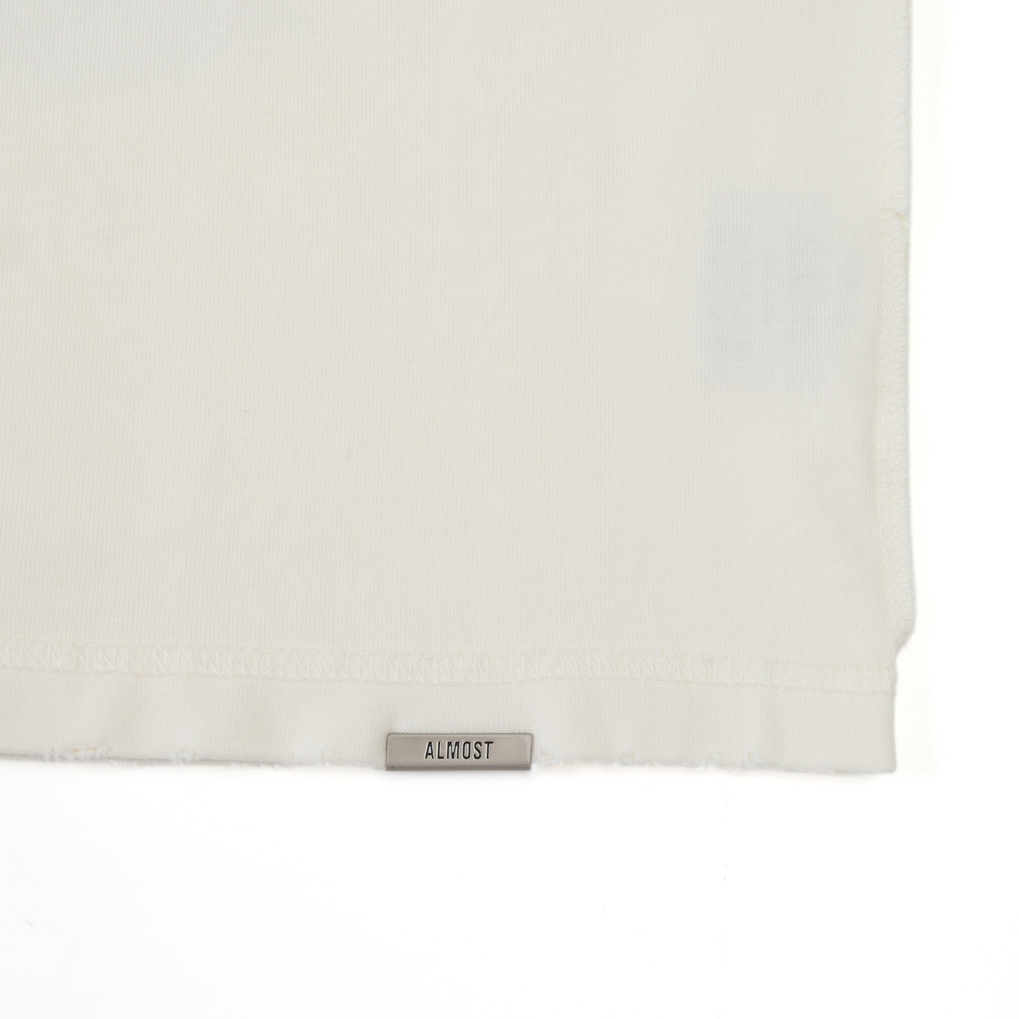 Fountain Tee – Cream – Bottom hem detail with ALMOST label