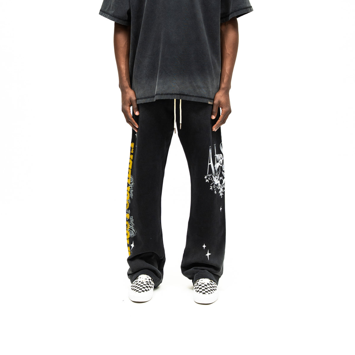 League Flare Sweatpants – Black – Front view on model styled with a tee, showing white drawstrings and flared graphic sweatpants