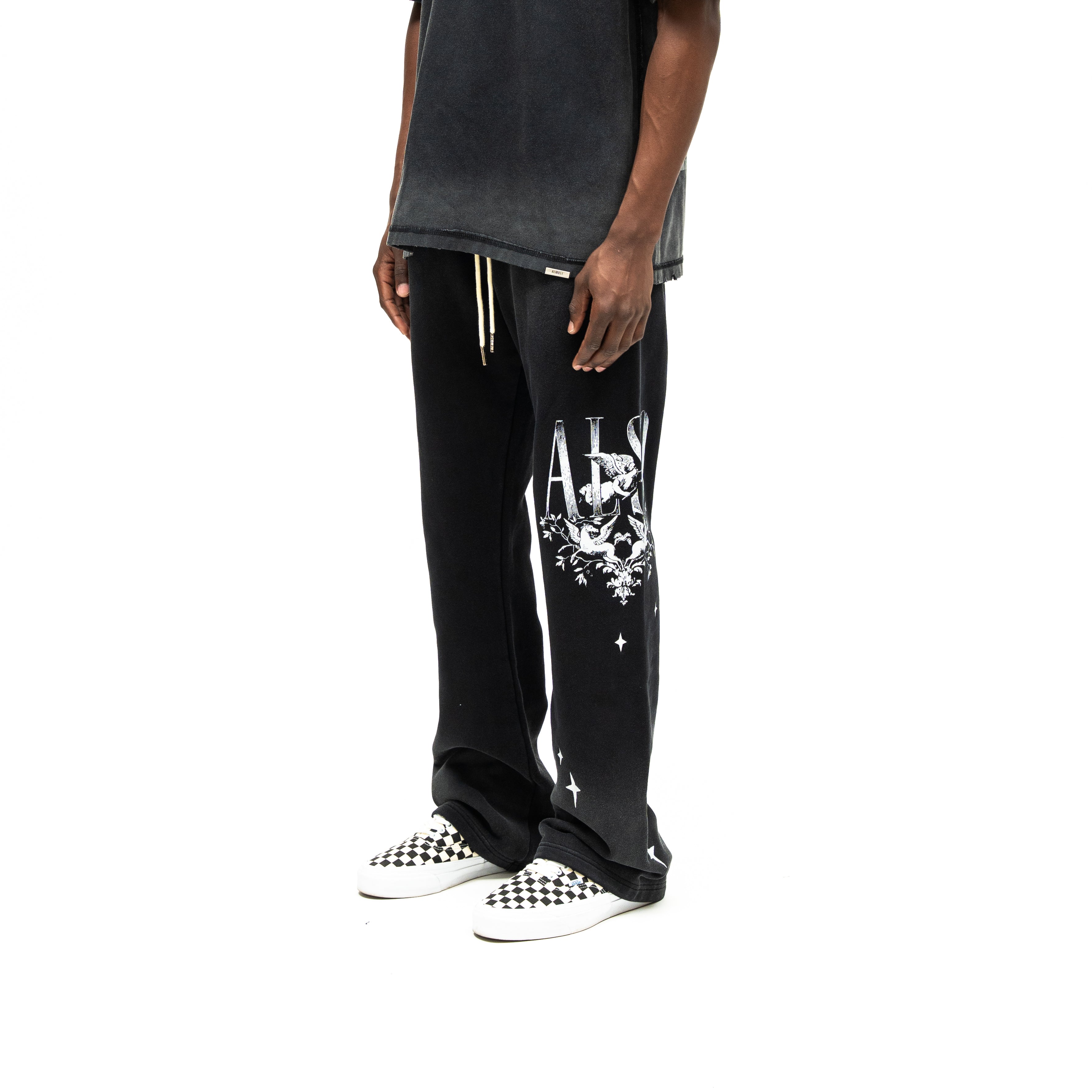 League Flare Sweatpants – Black – Three-quarter front view on model styled with a tee, showing white cherub and star leg graphics