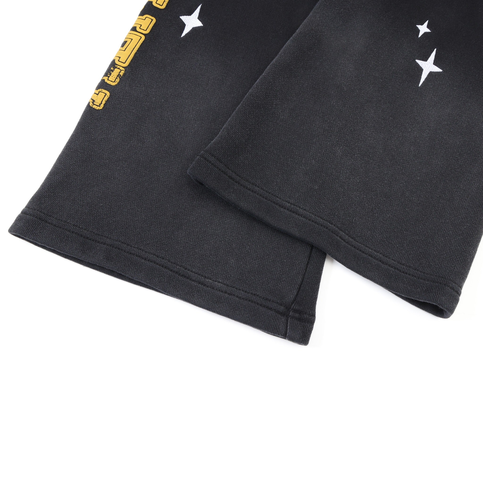 League Flare Sweatpants – Black – Close-up of stitched flared hems with white star graphics