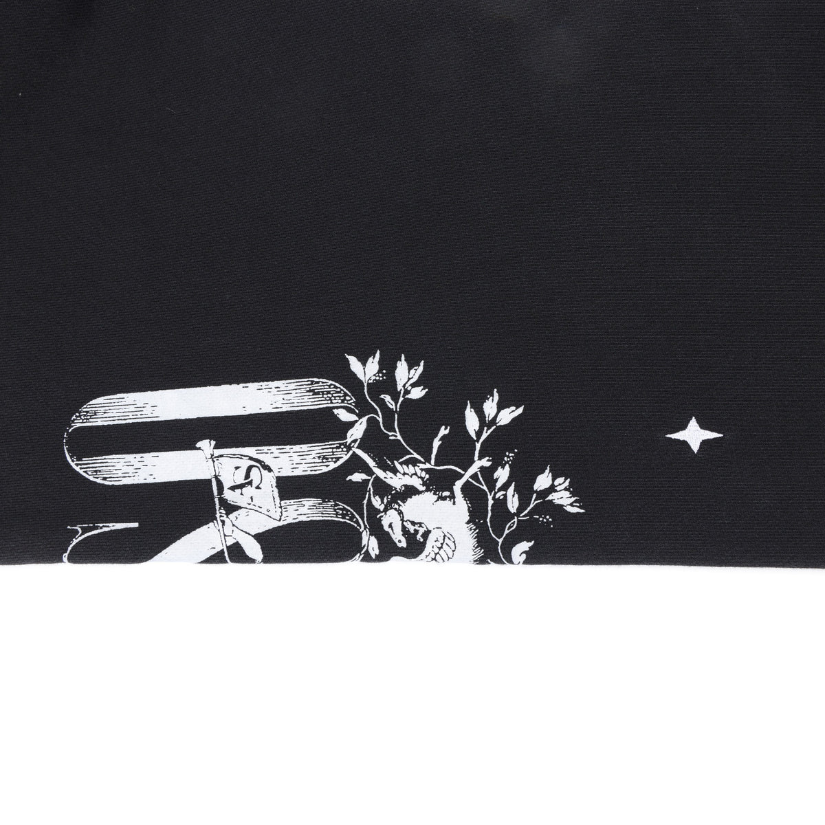 League Flare Sweatpants – Black – Close-up of leg fabric with partial white lettering, winged figure, and star graphic