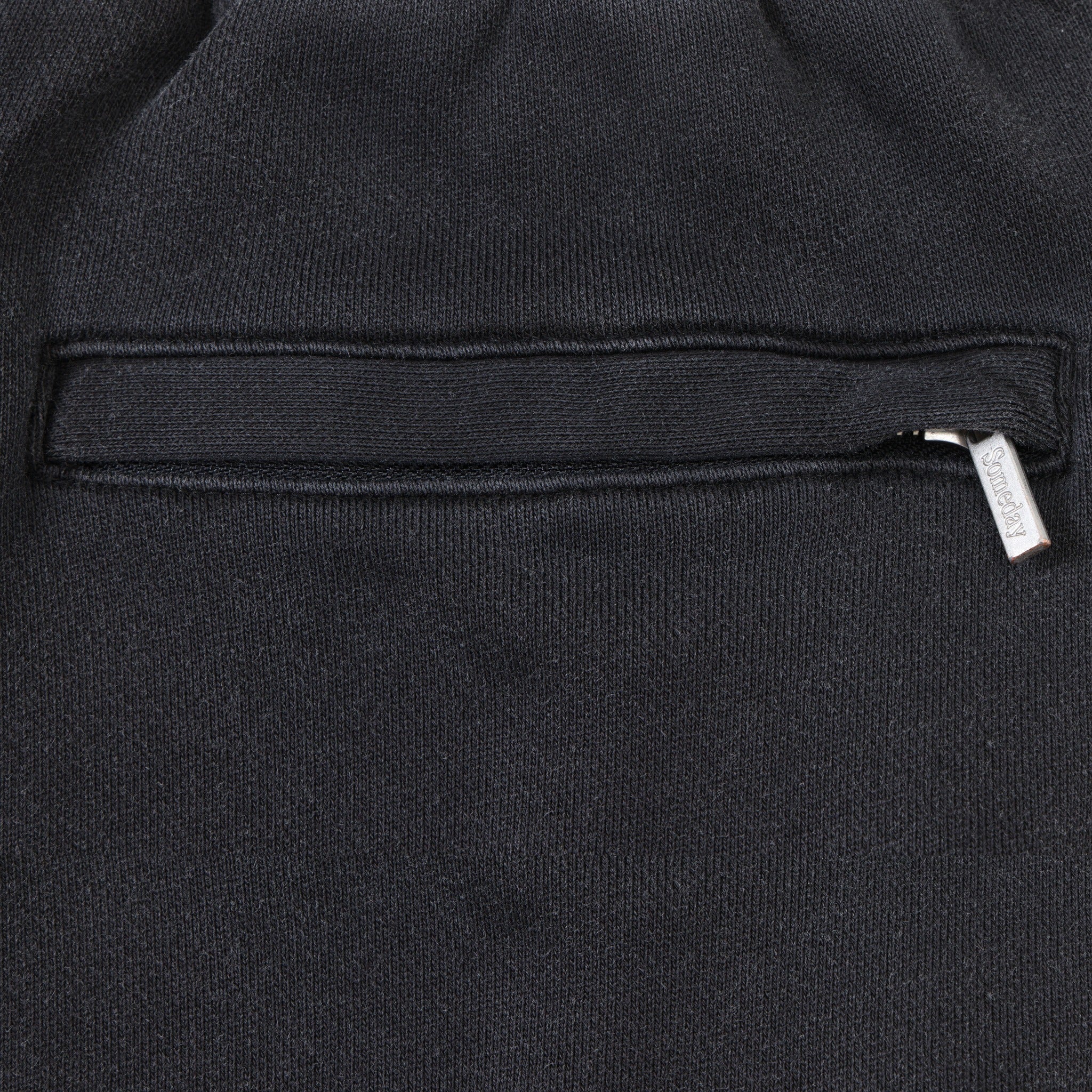 League Flare Sweatpants – Black – Close-up of zippered back pocket with silver-tone branded zipper pull