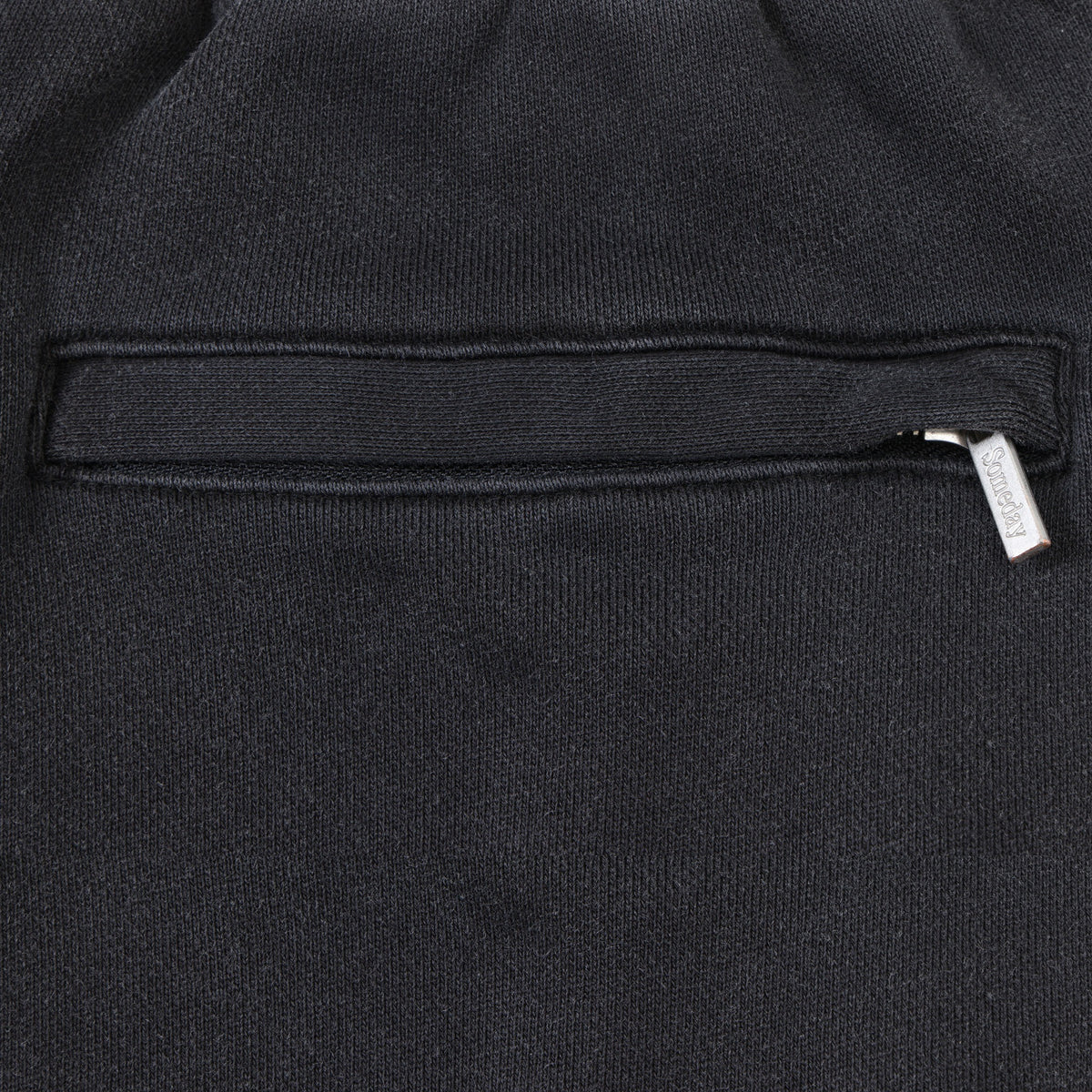 League Flare Sweatpants – Black – Close-up of zippered back pocket with silver-tone branded zipper pull