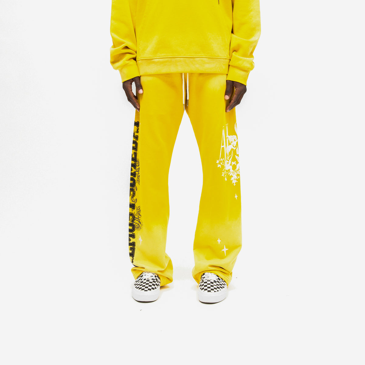 League Flare Sweatpants – Yellow – Front view on model styled with a matching hoodie, showing white drawstrings and flared graphic legs