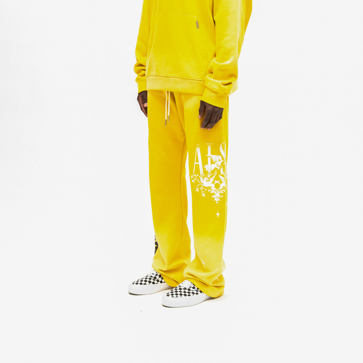 League Flare Sweatpants – Yellow – Three-quarter front view on model styled with a matching hoodie, showing white leg artwork and flared hems