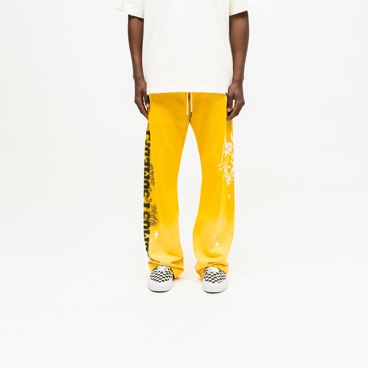 League Flare Sweatpants – Yellow – Front view on model styled with a cream tee, showing white drawstrings and contrasting leg graphics