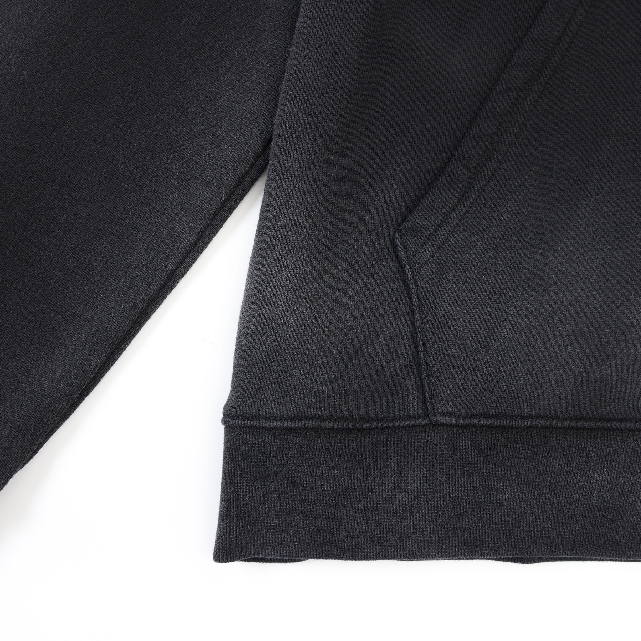 League Hoodie – Black – Close-up of kangaroo pocket seam and ribbed bottom hem
