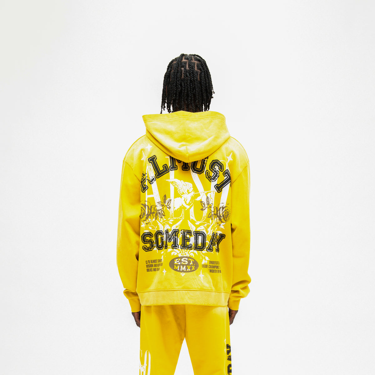 League Hoodie – Yellow – Back view on model showing large ALMOST SOMEDAY lettering, cherub, roses, and stars