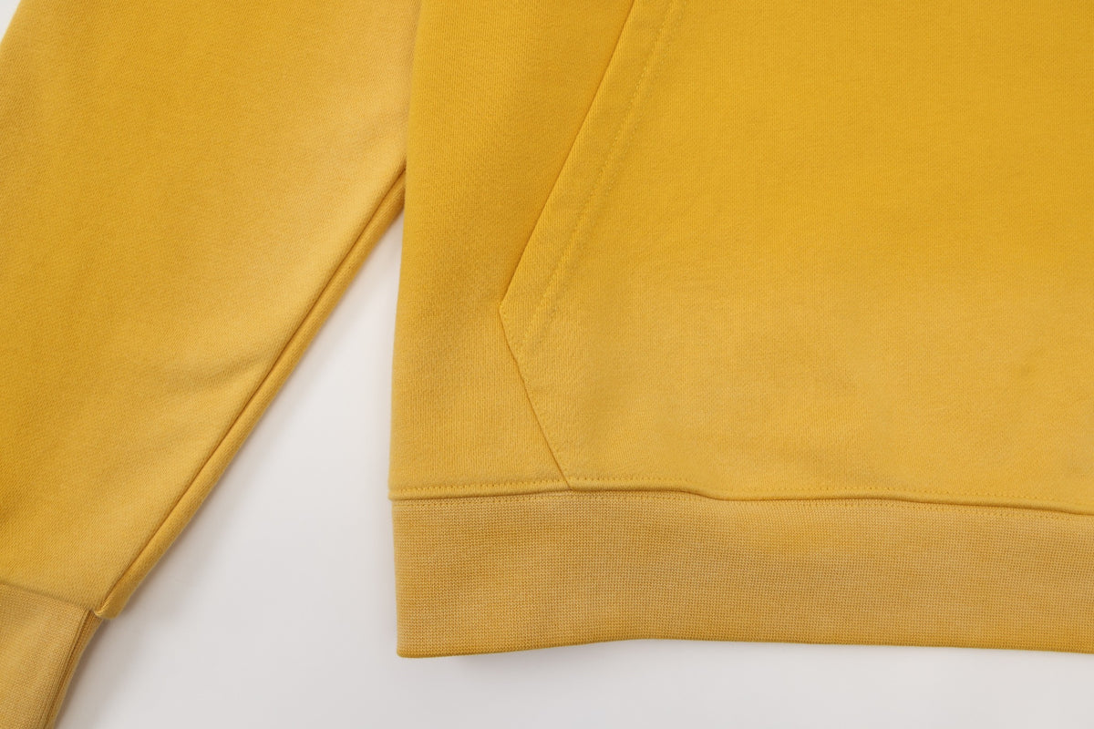League Hoodie – Yellow – Close-up of kangaroo pocket seam and ribbed bottom hem