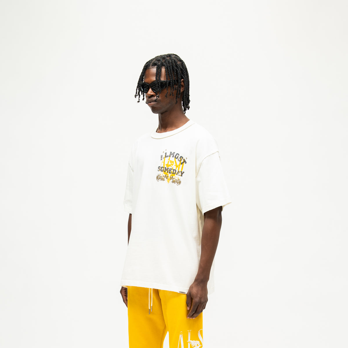 League Tee – Cream – Three-quarter front view on model showing chest graphic and dropped shoulders