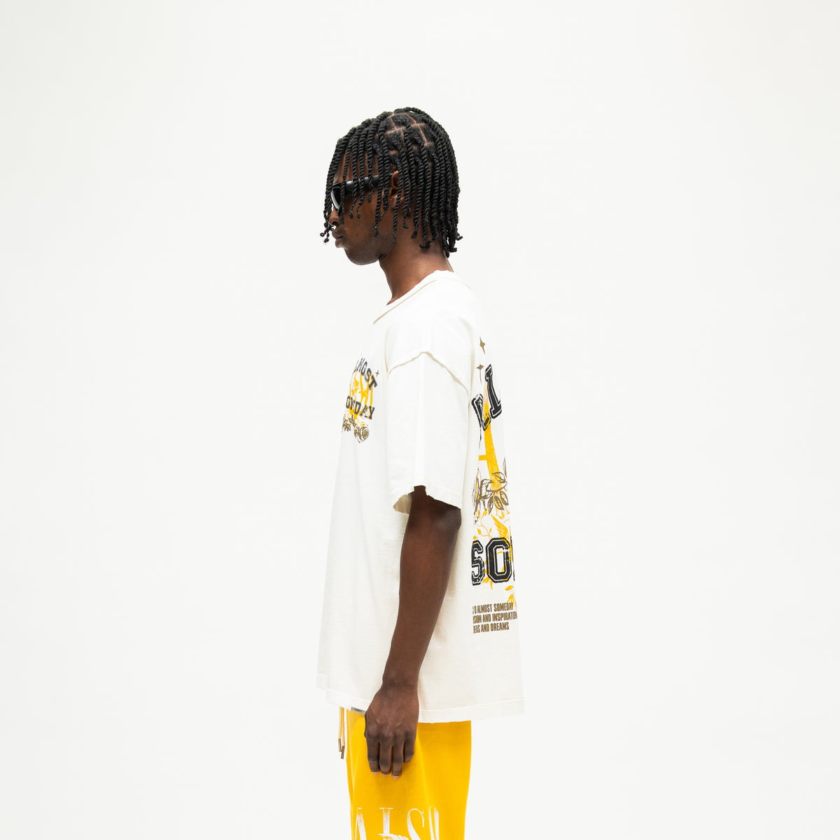 League Tee – Cream – Side view on model showing relaxed silhouette, short sleeves, and partial back graphic