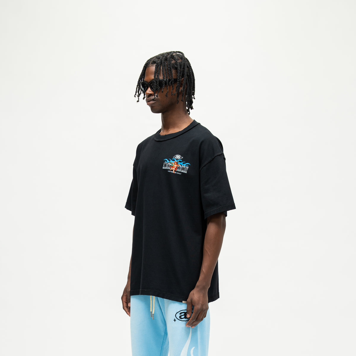 Members Tee – Black – Three-quarter front view on model showing chest artwork and dropped shoulders