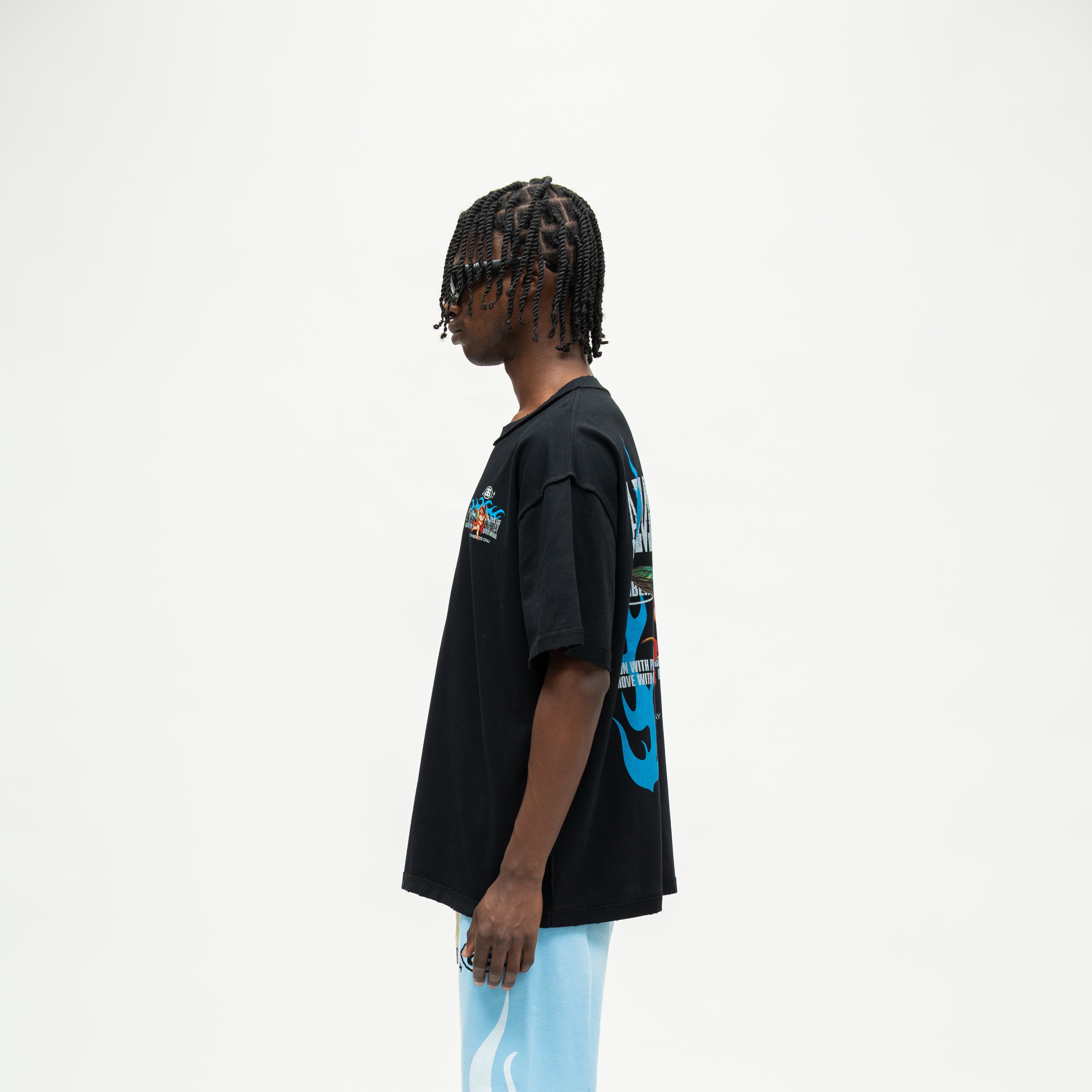 Members Tee – Black – Side view on model showing short sleeve, straight hem, and partial blue back artwork