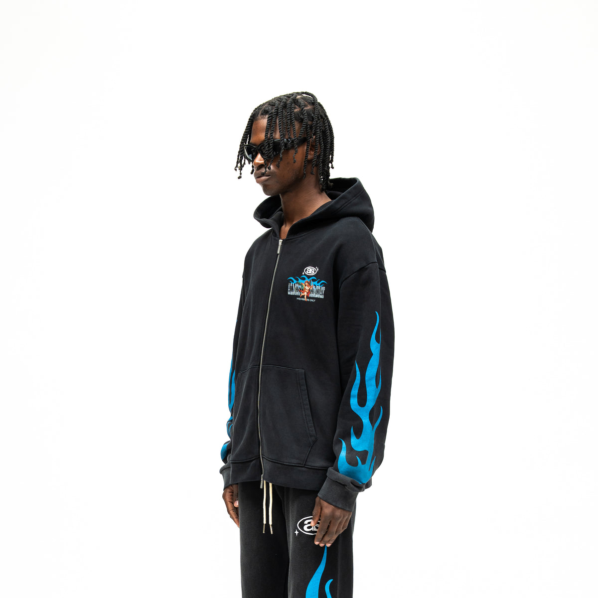 Members Zip Hoodie – Black – Three-quarter front view on model showing chest artwork, dropped shoulders, and blue sleeve flames