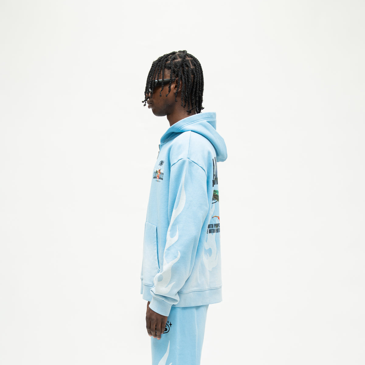 Members Zip Hoodie – Light Blue – Side view on model showing hood, white flame sleeve graphic, and ribbed cuff and hem