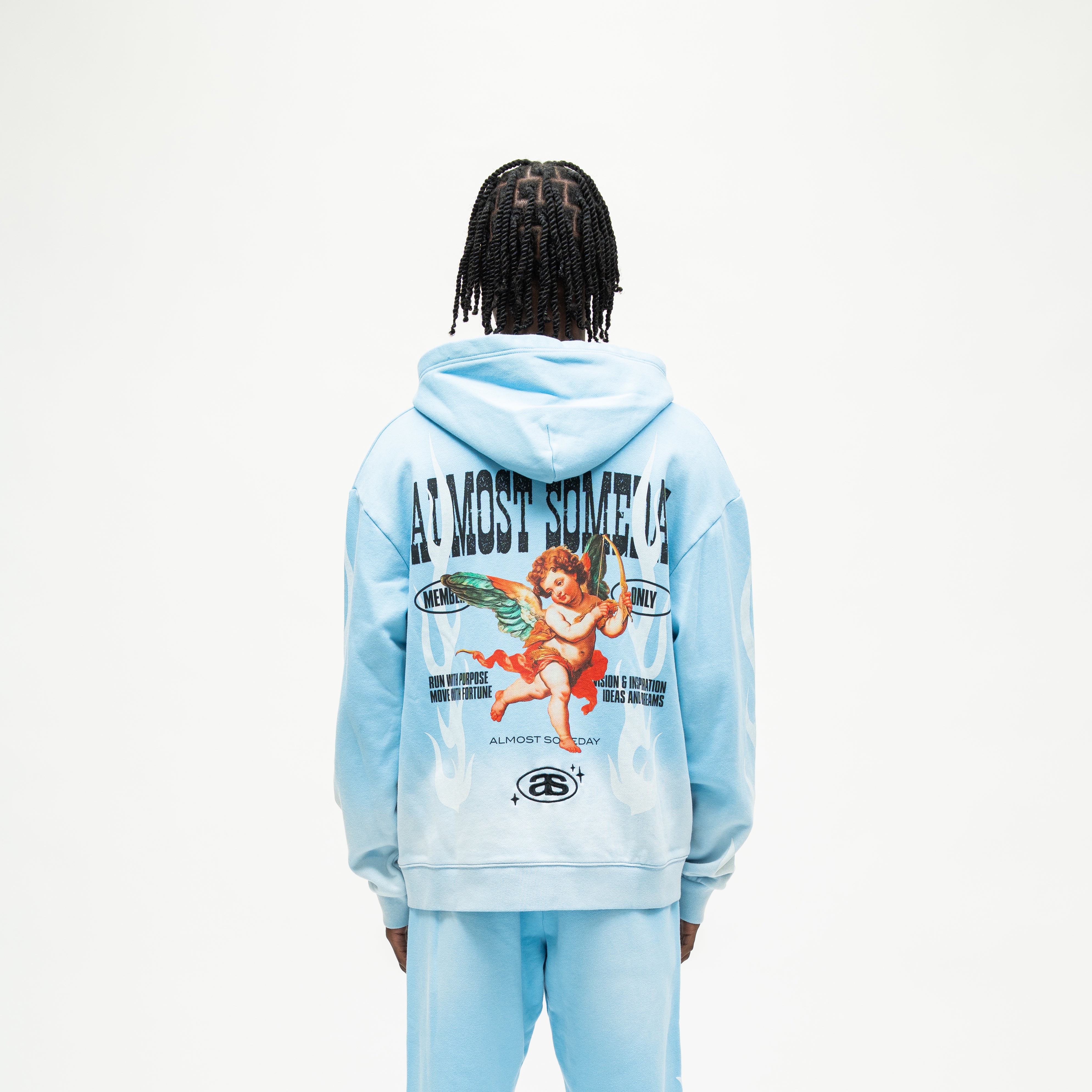 Members Zip Hoodie – Light Blue – Back view on model showing hood, winged cherub with bow, white flames, and Almost Someday lettering