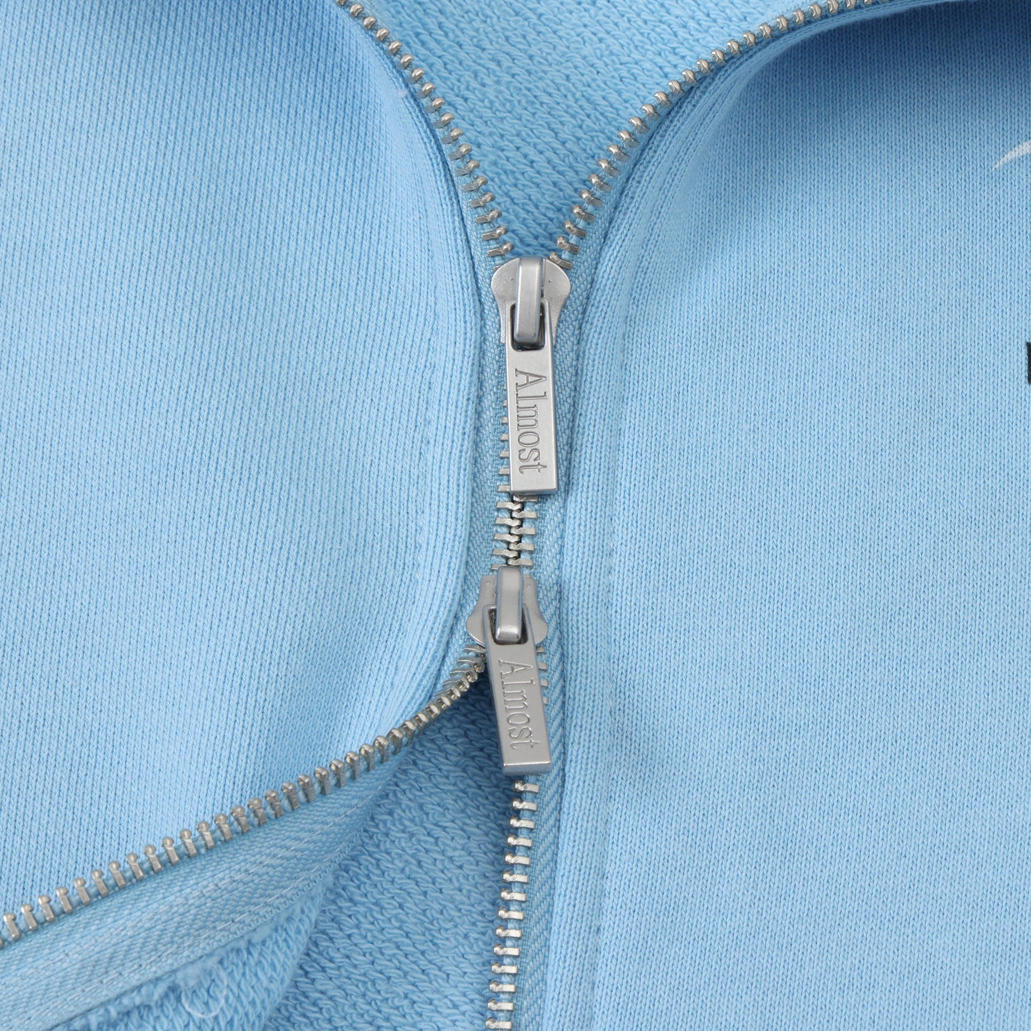 Members Zip Hoodie – Light Blue – Close-up of two-way zipper with branded metal pulls